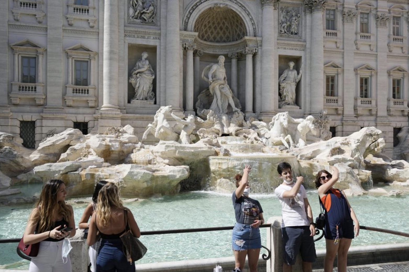 In this Friday, June 4, 2021 file photo, tourists throw their coins into the Trevi fountain as a wish to come back to the eternal city, in downtown Rome. European Union members agreed Wednesday, June 16, 2021, to add the U.S. to the list of countries in whose cases restrictions on non-essential travel should be lifted.