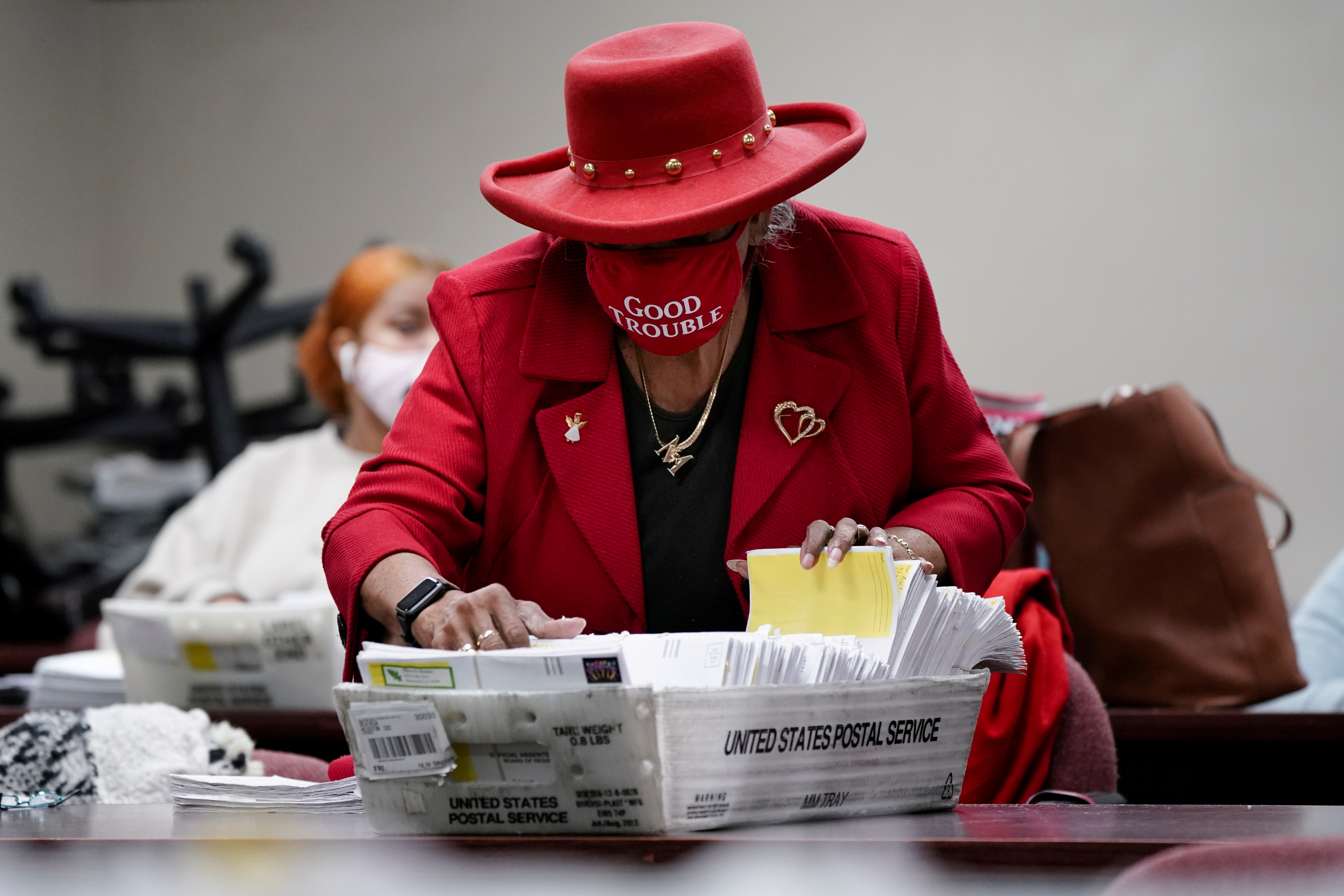 A DeKalb County election worker wearing a 'Good Trouble' face mask sorts empty absentee ballot envelopes following the Senate runoff elections in Decatur, Georgia, Jan. 6, 2021. 