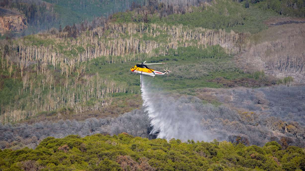 A firefighting helicopter is seen fighting the Pack Creek Fire in San Juan County on Tuesday, June 15, 2021.