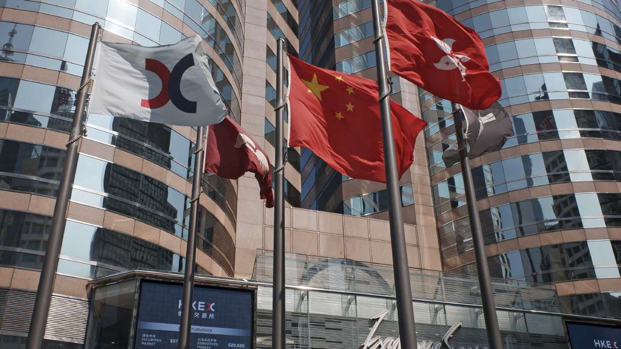 FILE - In this Oct. 9, 2019, file photo, flags are raised outside the Hong Kong Exchange Square building in Central of Hong Kong. The Hong Kong Stock Exchange said it was hit by technical problems Thursday as a wave of brief internet outages appeared to hit dozens of financial institutions, airlines and other companies across the globe.