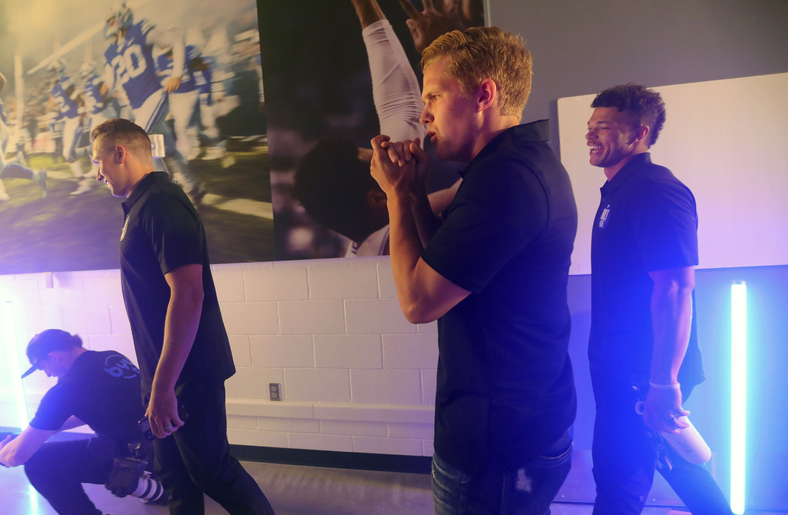 BYU quarterbacks Baylor Romney, left, Jacob Conover and Jaren Hall walk through a hall with a fog machine for photos during BYU football media day at the BYU Broadcasting Building in Provo on Thursday, June 17, 2021.