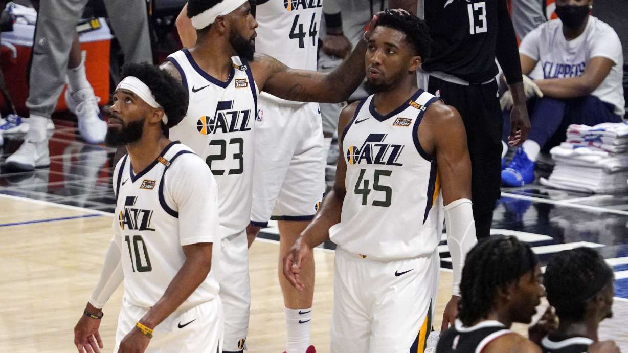 Utah Jazz forward Royce O'Neale, center, pats guard Donovan Mitchell, right, on the head as guard Mike Conley walks away in the closing minutes during the second half in Game 6 of a second-round NBA basketball playoff series against the Los Angeles Clippers Friday, June 18, 2021, in Los Angeles.