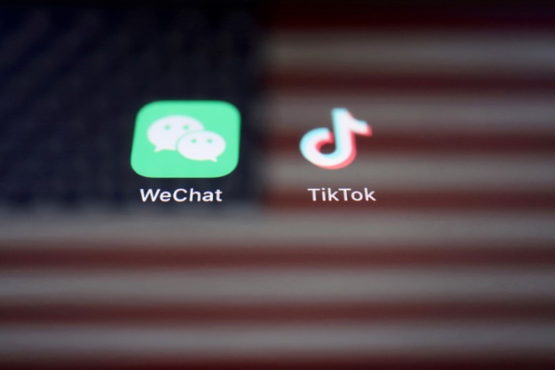 FILE: A reflection of the U.S. flag is seen on the signs of the WeChat and TikTok apps in this illustration picture taken September 19, 2020. 