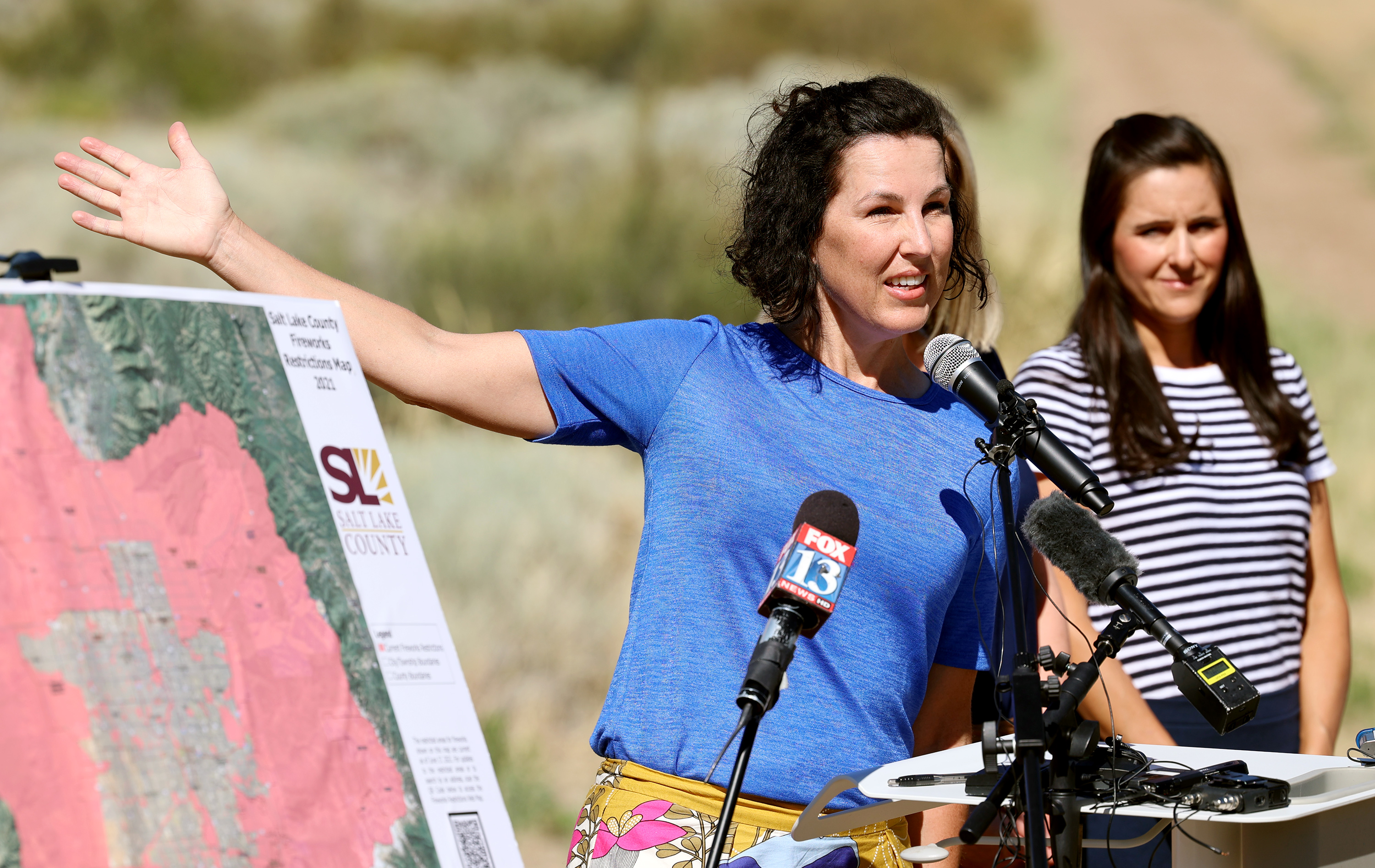Rep. Suzanne Harrison, D-Sandy, gestures toward the houses and open space as she joins Salt Lake County Mayor Jenny Wilson, Salt Lake County Emergency Management Director Clint Mecham, and others gathered on the trail at Dimple Dell Park near the Wrangler Trailhead in Sandy for a press conference on Monday, June 21, 2021. Officials urged residents to not set off fireworks this year and celebrate in other ways.