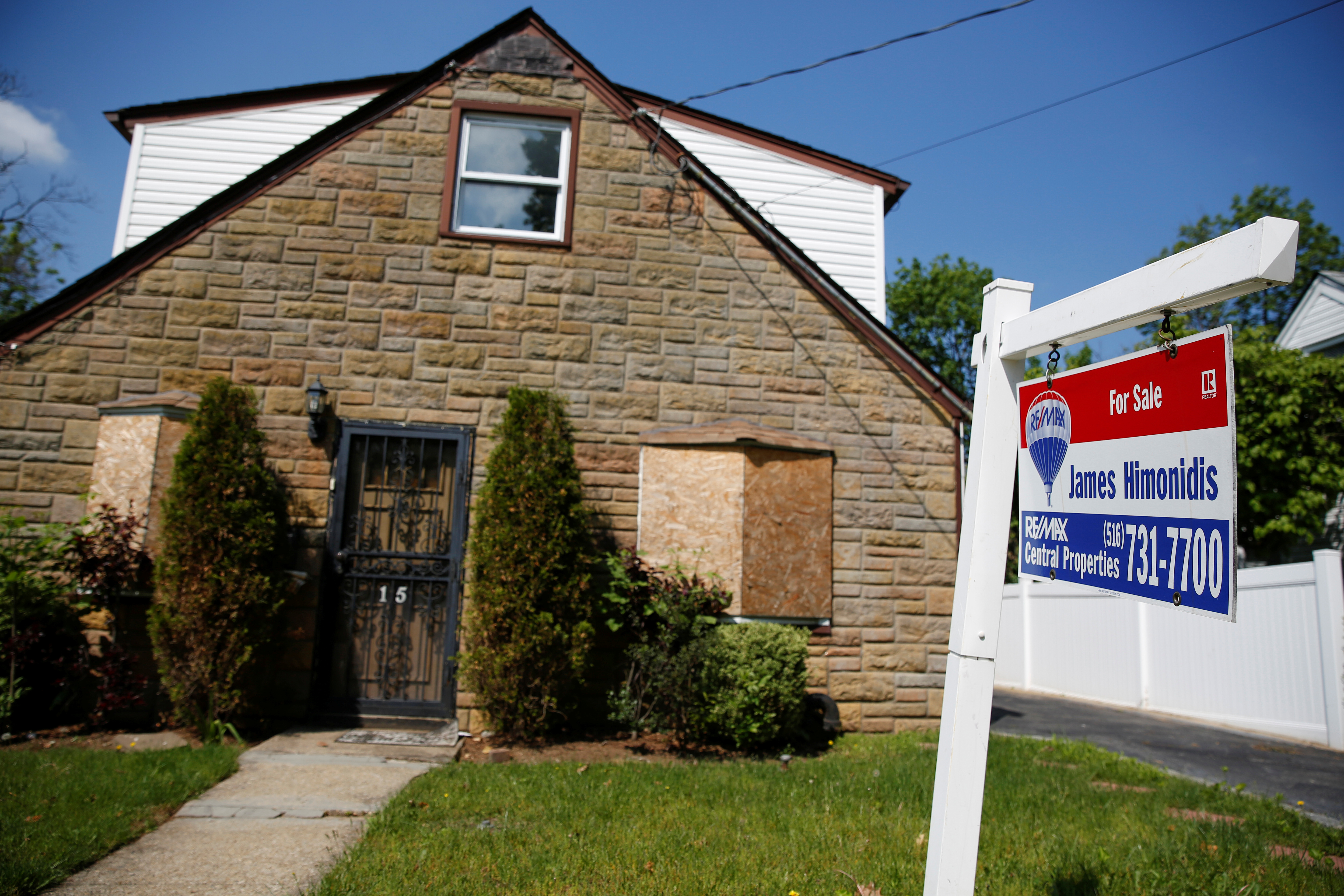 A 'for sale' is seen outside a single-family house in Garden City, New York, on May 23, 2016. 
