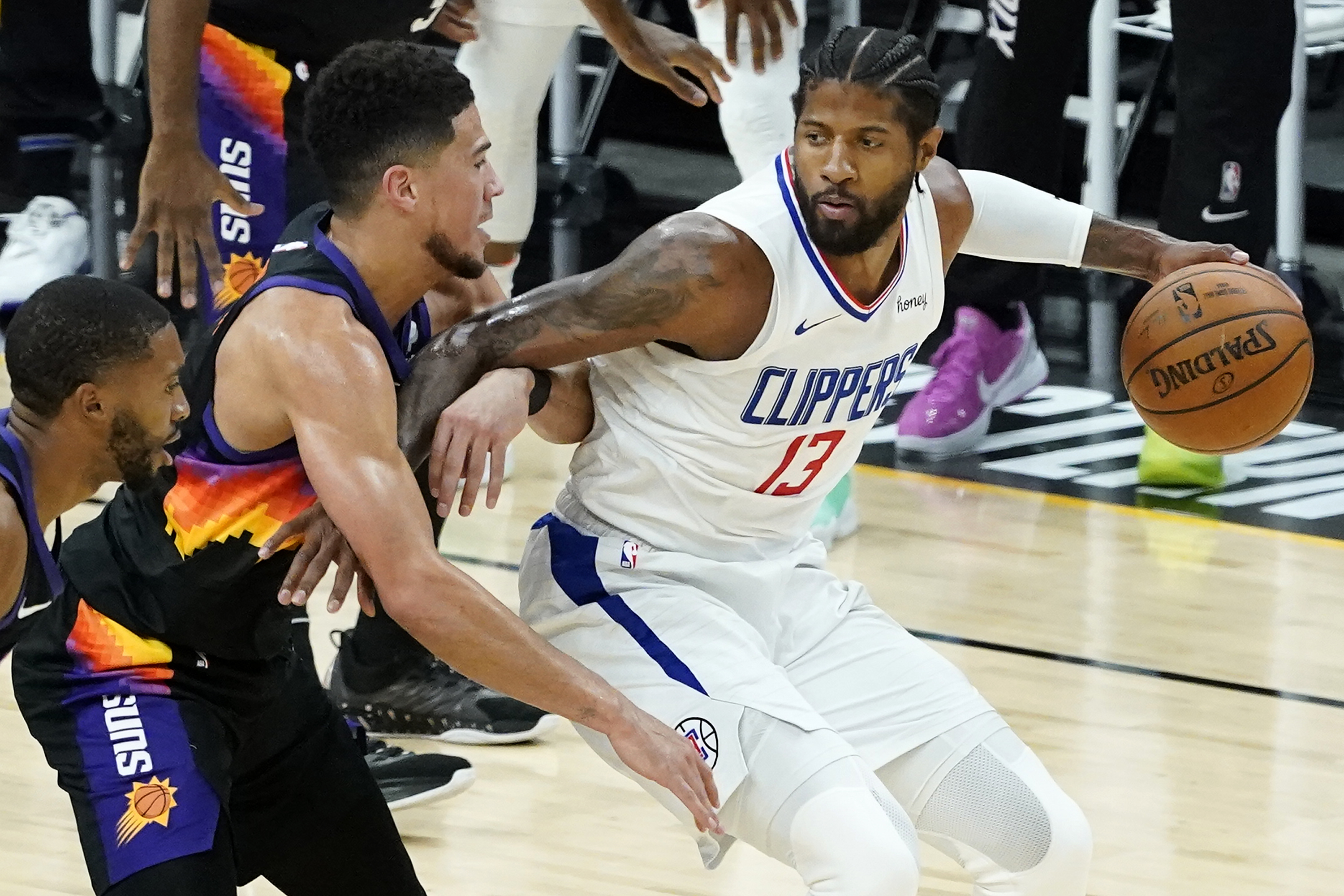 Los Angeles Clippers guard Paul George, right, is defended by Phoenix Suns guard Devin Booker during the first half of Game 2 of the NBA basketball Western Conference Finals, Tuesday, June 22, 2021, in Phoenix.
