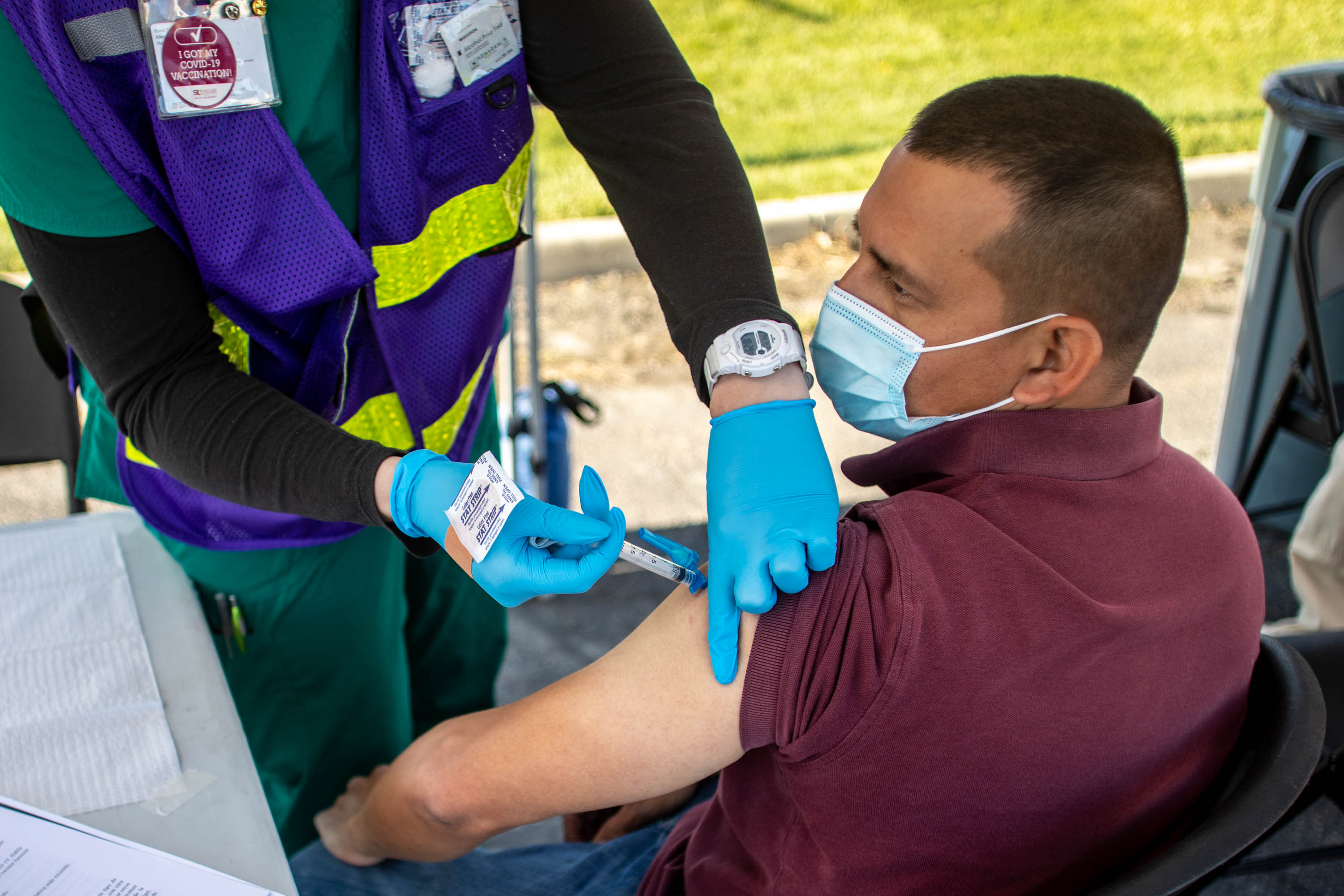 Health care worker Nadia Swanson, left, gives Carlos Ramirez, right, a COVID-19 vaccine at a pop-up vaccination event at Reams in Magna on Monday, May 3, 2021.