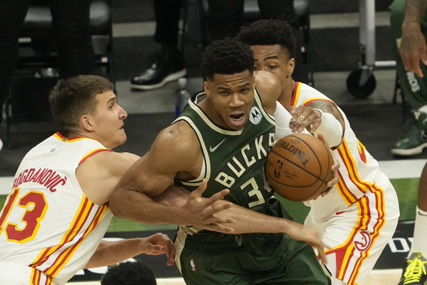 Milwaukee Bucks' Giannis Antetokounmpo tries to get past Atlanta Hawks' Bogdan Bogdanovic (13) and John Collins during the first half of Game 1 of the NBA Eastern Conference basketball finals game Wednesday, June 23, 2021, in Milwaukee.