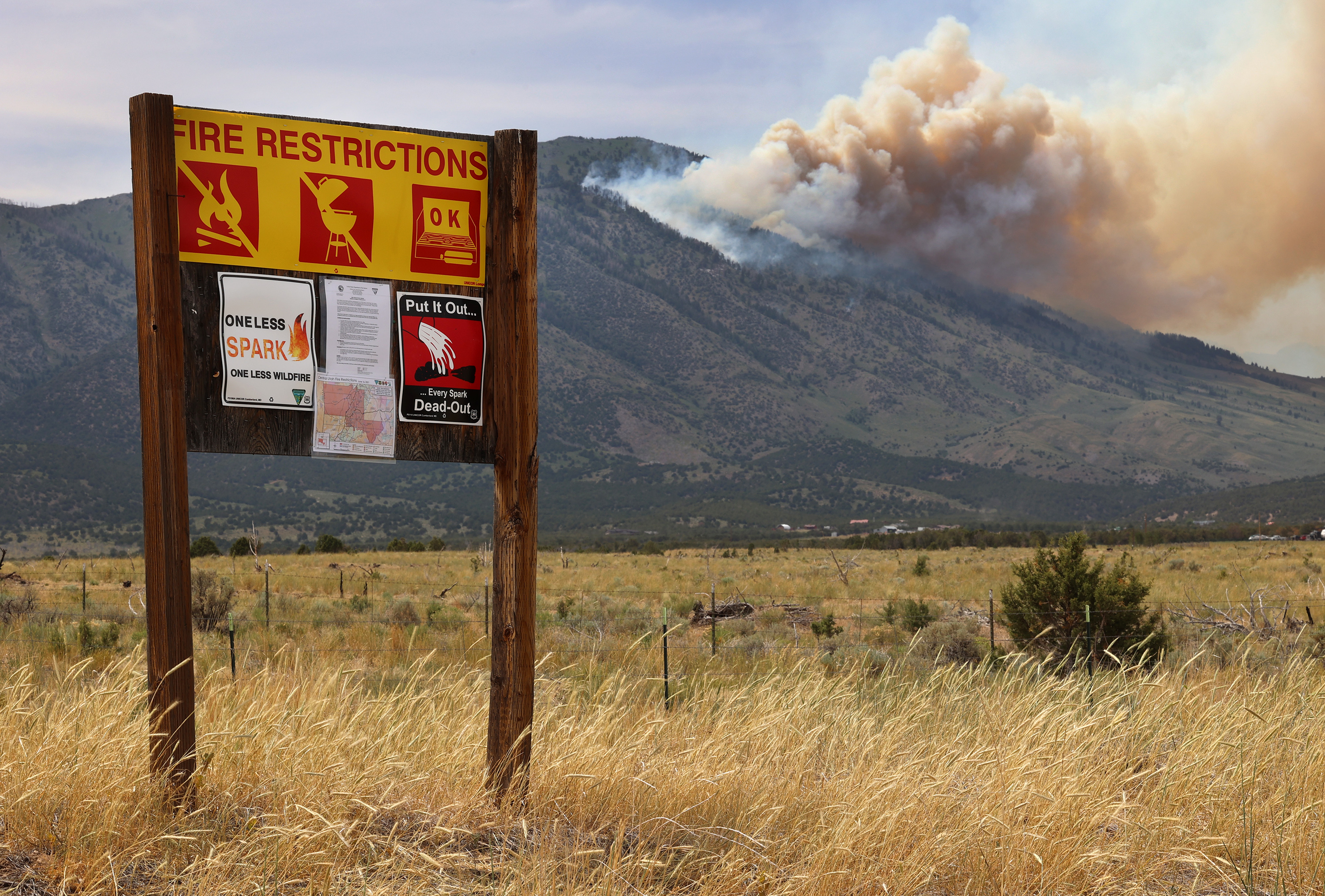 A fire restriction sign sits along the road in Rush Valley as a wildfire burns on Victory Mountain in Morgan Canyon in Tooele County on Tuesday, June 22, 2021. If you start a fire this summer, you may be held responsible for fire suppression costs which are quite expensive.