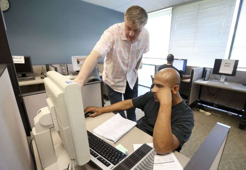 Stephen Cashon, an employment counselor with the Utah
Department of Workforce Services, helps Juan Rodriguez apply for a
new ID so that he can apply for jobs at the department’s offices in
Salt Lake City on Tuesday, June 22, 2021.