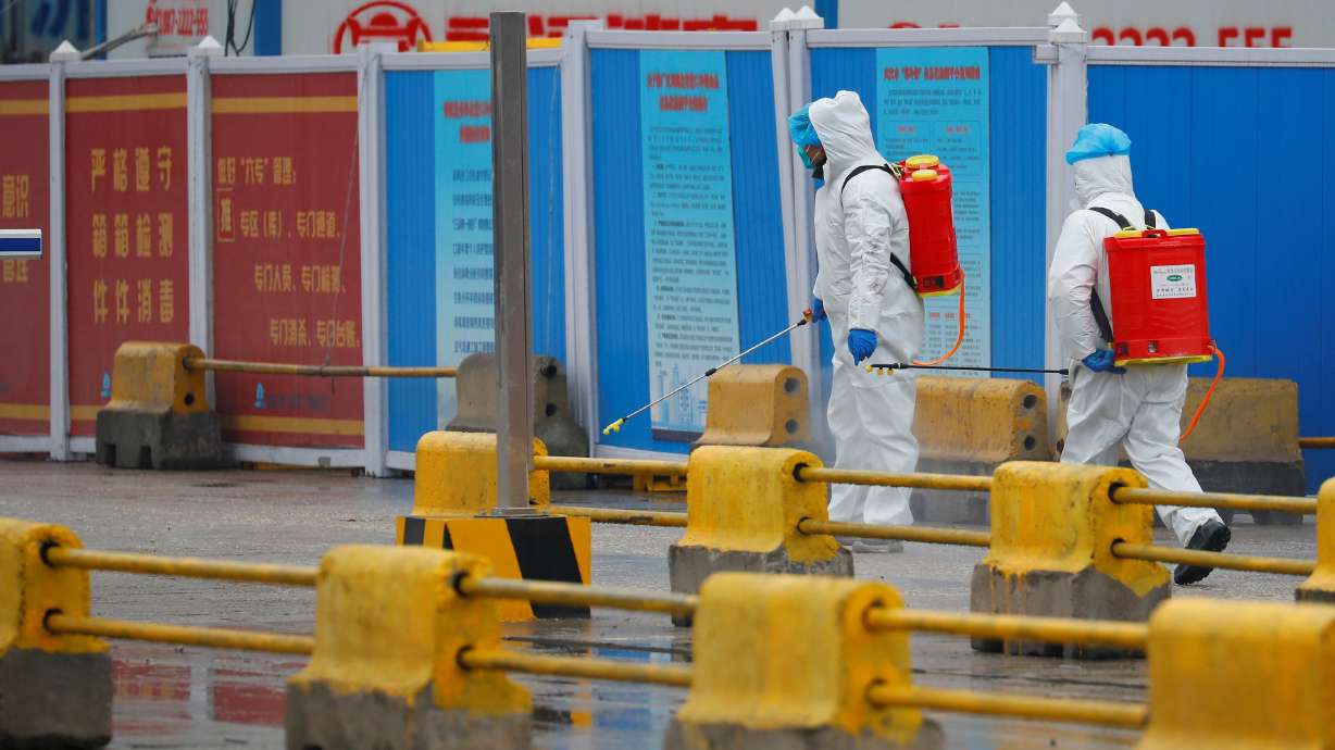 Workers in PPE spray the ground with disinfectant in Baishazhou market during a visit of World Health Organization team tasked with investigating the origins of the coronavirus pandemic, in Wuhan, Hubei province, China, Jan. 31, 2021.