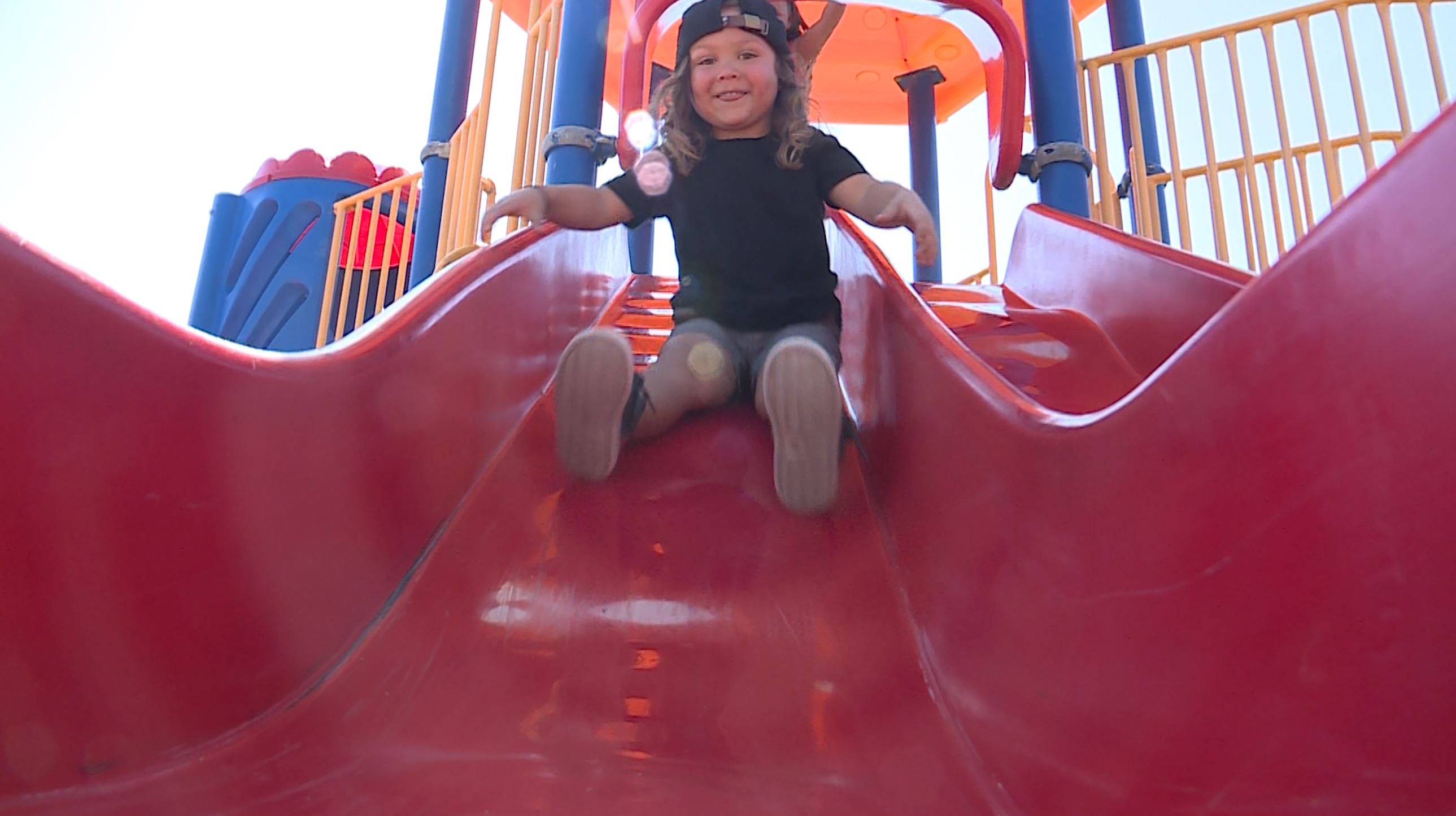 Titan Larsen smiles as he goes down a slide. Megan Larsen is grateful the U.S. Synthetic on-site clinic is always available to care for her young, growing family when she needs them.