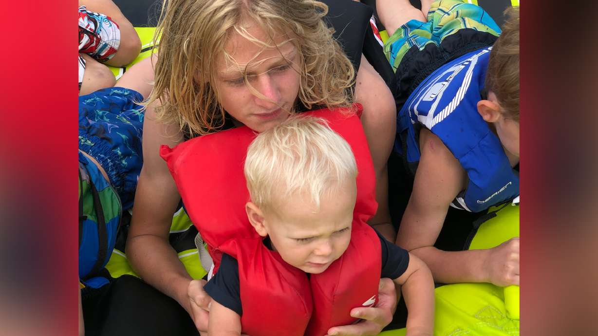 Arianne Brown's children hold tight to the tube pulled by the family's boat.
