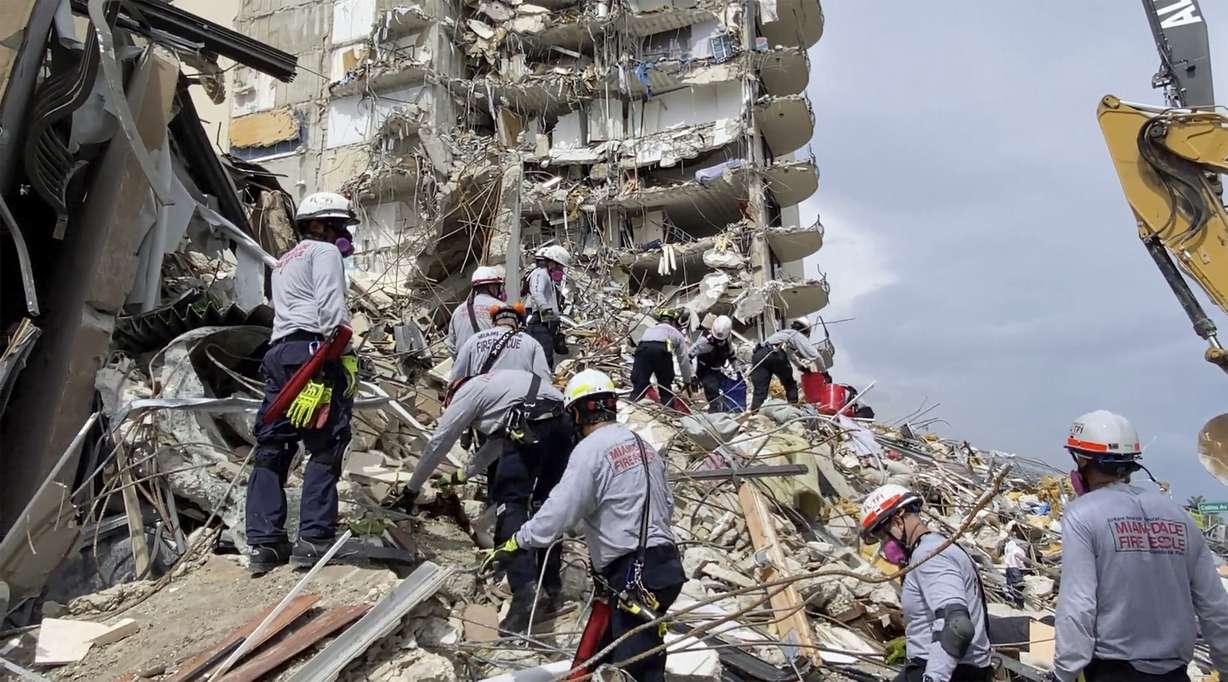 This photo provided by Miami-Dade Fire Rescue, search and rescue personnel search for survivors through the rubble at the Champlain Towers South Condo in Surfside, Fla., section of Miami, Friday, June 25, 2021. The apartment building partially collapsed on Thursday.