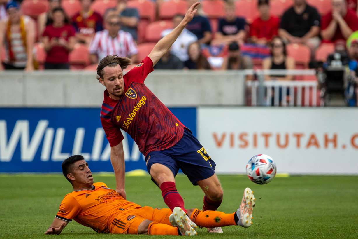 Real Salt Lake midfielder Nick Besler (13) battles the Houston Dynamos for the ball as RSL and Houston play an MLS soccer game at Rio Tinto Stadium in Sandy on Saturday, June 26, 2021.
