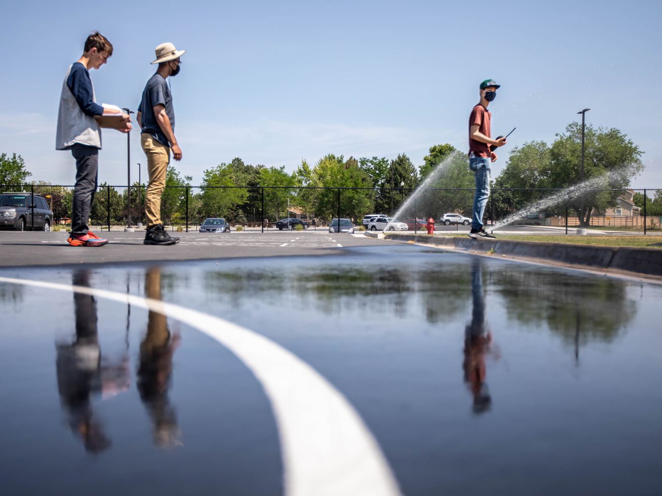 Interns Asher Stewart, left, Isaac Middlemas and Jaron Tsao take notes and check sprinklers for their type and if they can
be more efficient at Altara Elementary School in Sandy on June 17, 2021. Building upon a successful Water Manager internship program that has saved upward of 20 million gallons of water annually for the past six years, mathematically inclined high school students this summer will undergo training on tracking water usage with the aim of applying just enough water to the district’s 370 acres of green space to keep fields healthy while maximizing their drought tolerance.