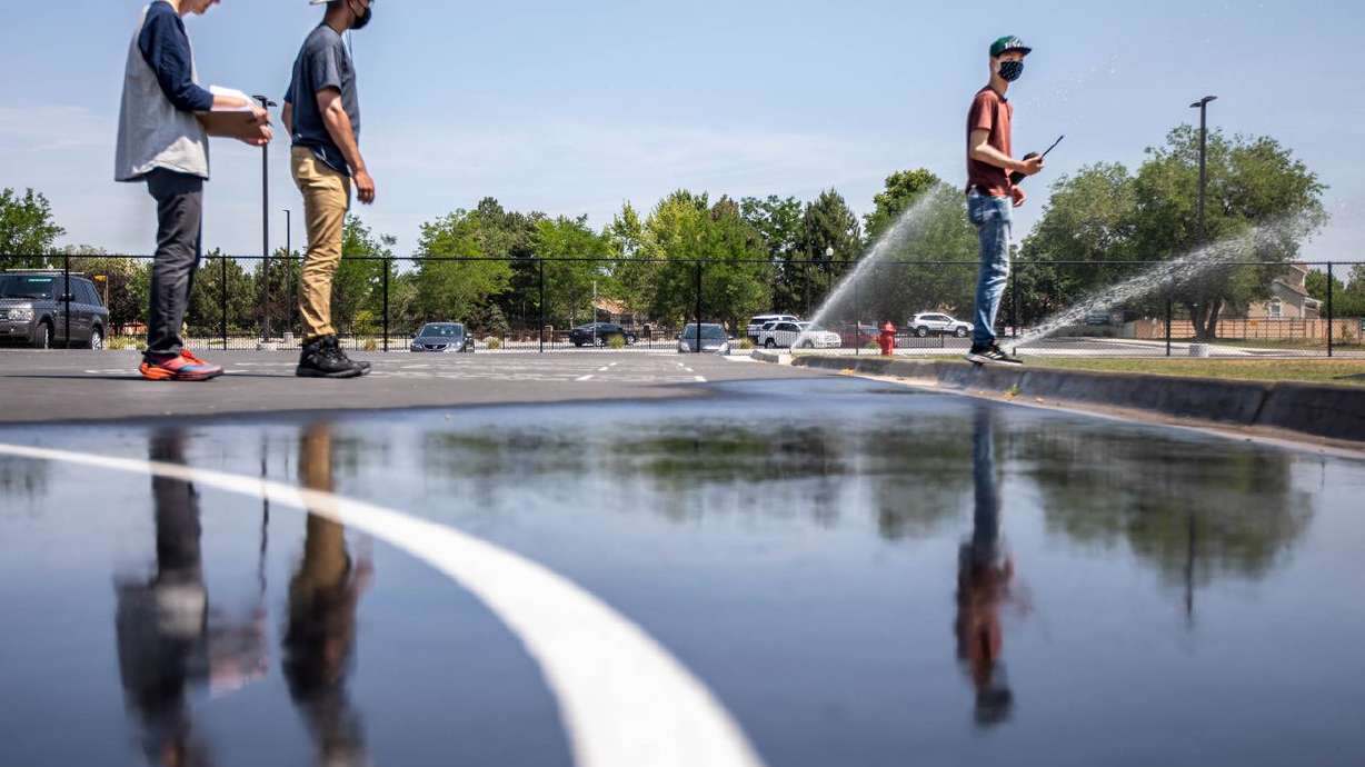 Interns Asher Stewart, left, Isaac Middlemas and Jaron Tsao take notes and check sprinklers for their type and if they can
be more efficient at Altara Elementary School in Sandy on June 17, 2021. Building upon a successful Water Manager internship program that has saved upward of 20 million gallons of water annually for the past six years, mathematically inclined high school students this summer will undergo training on tracking water usage with the aim of applying just enough water to the district’s 370 acres of green space to keep fields healthy while maximizing their drought tolerance.