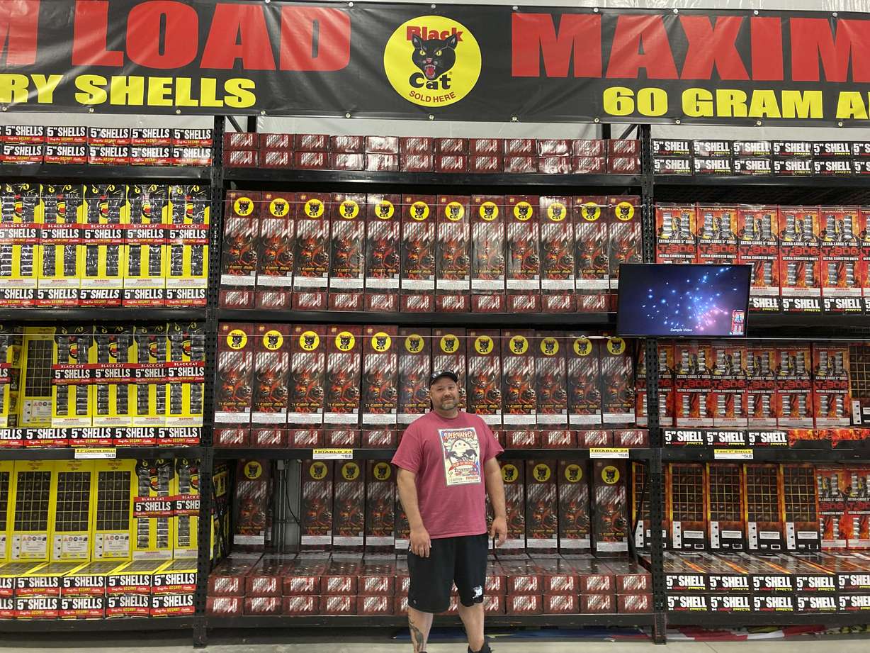 Ben Laws, manager of Pyro City fireworks stands in front of shelves of fireworks sold at his store near Cheyenne, Wyo., Tuesday, June 22, 2021. People from states with fireworks restrictions often travel to state-line stores to stock up for the July 4th holiday.