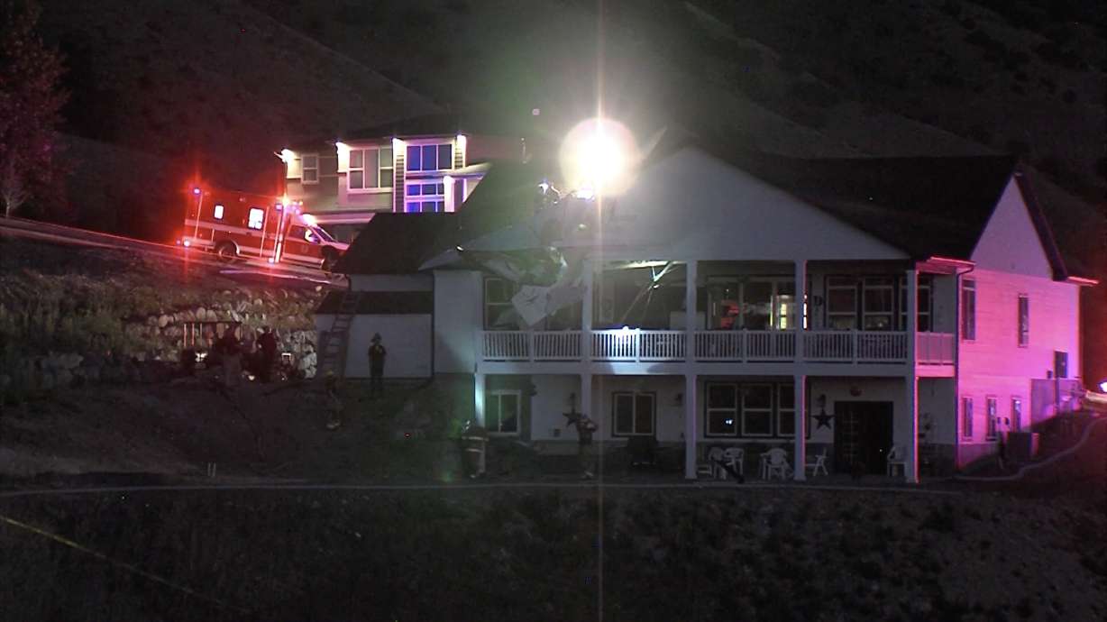 Police investigate the scene where a man died after the small plane he was piloting crashed into a house in North Logan on Saturday, June 26, 2021.