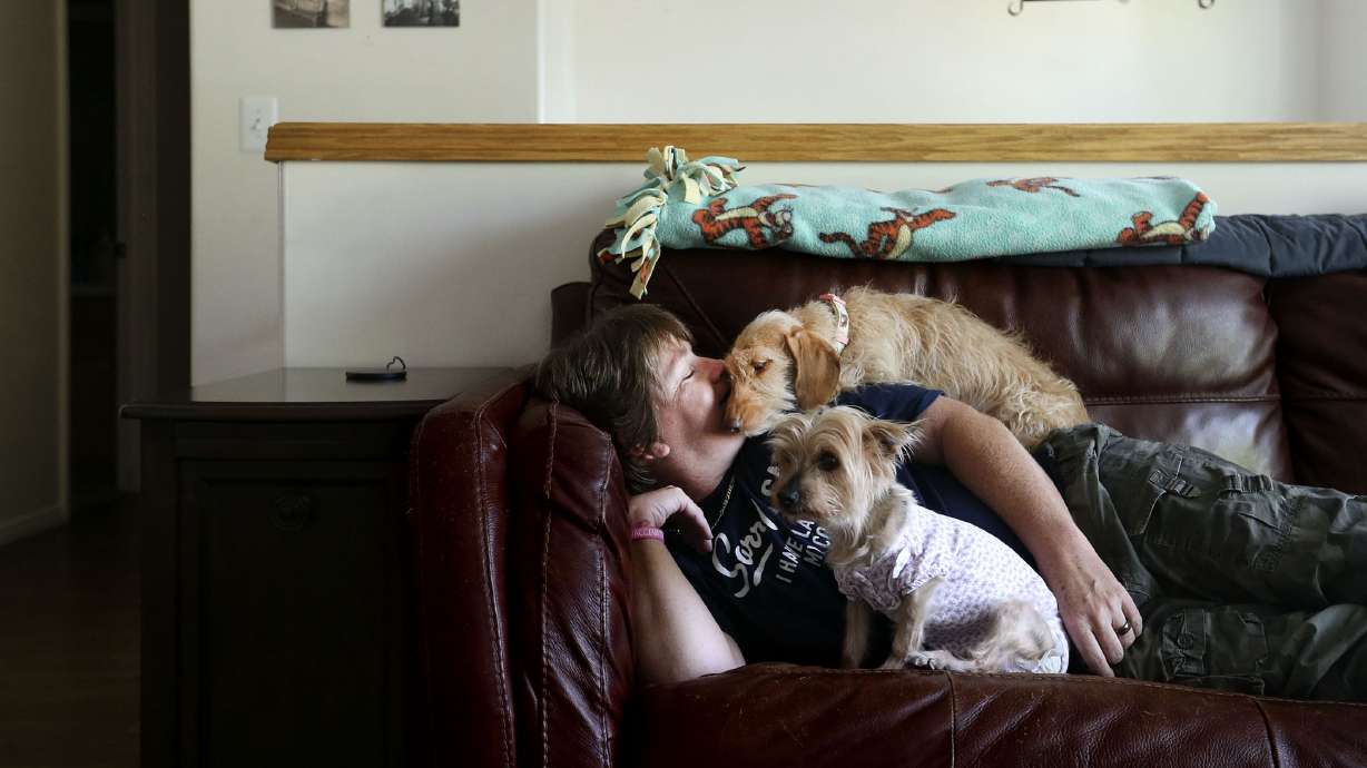 Sherry Munsell relaxes with her dogs after work in her Clinton home on Tuesday, June 15, 2021. Munsell earns $17 an hour as a truck driver and occasionally struggles to pay rent.