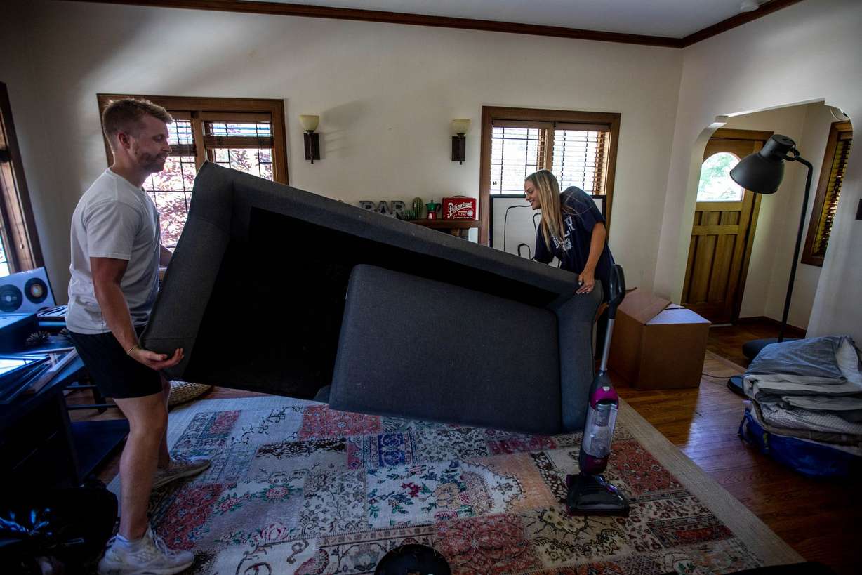 Max McVicker, left, and his roommate, Sadie Texer, right, move a couch at Texer’s new home in Salt Lake City on Saturday June 12, 2021.