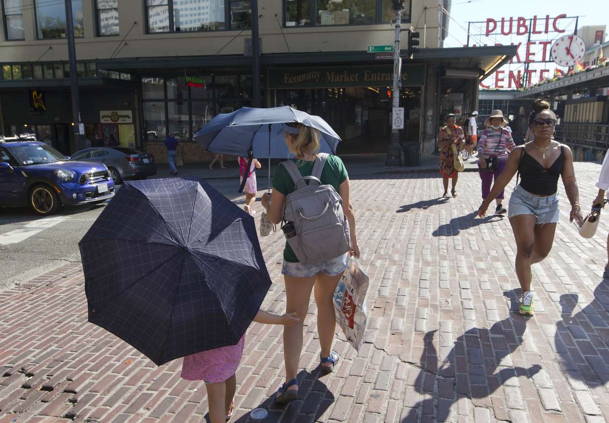 Sabina Ehmann and her daughter Vivian, visiting Seattle from North Carolina, are prepared with umbrellas to shield the sun during a heat wave hitting the Pacific Northwest on Sunday, June 27, 2021, in Seattle.