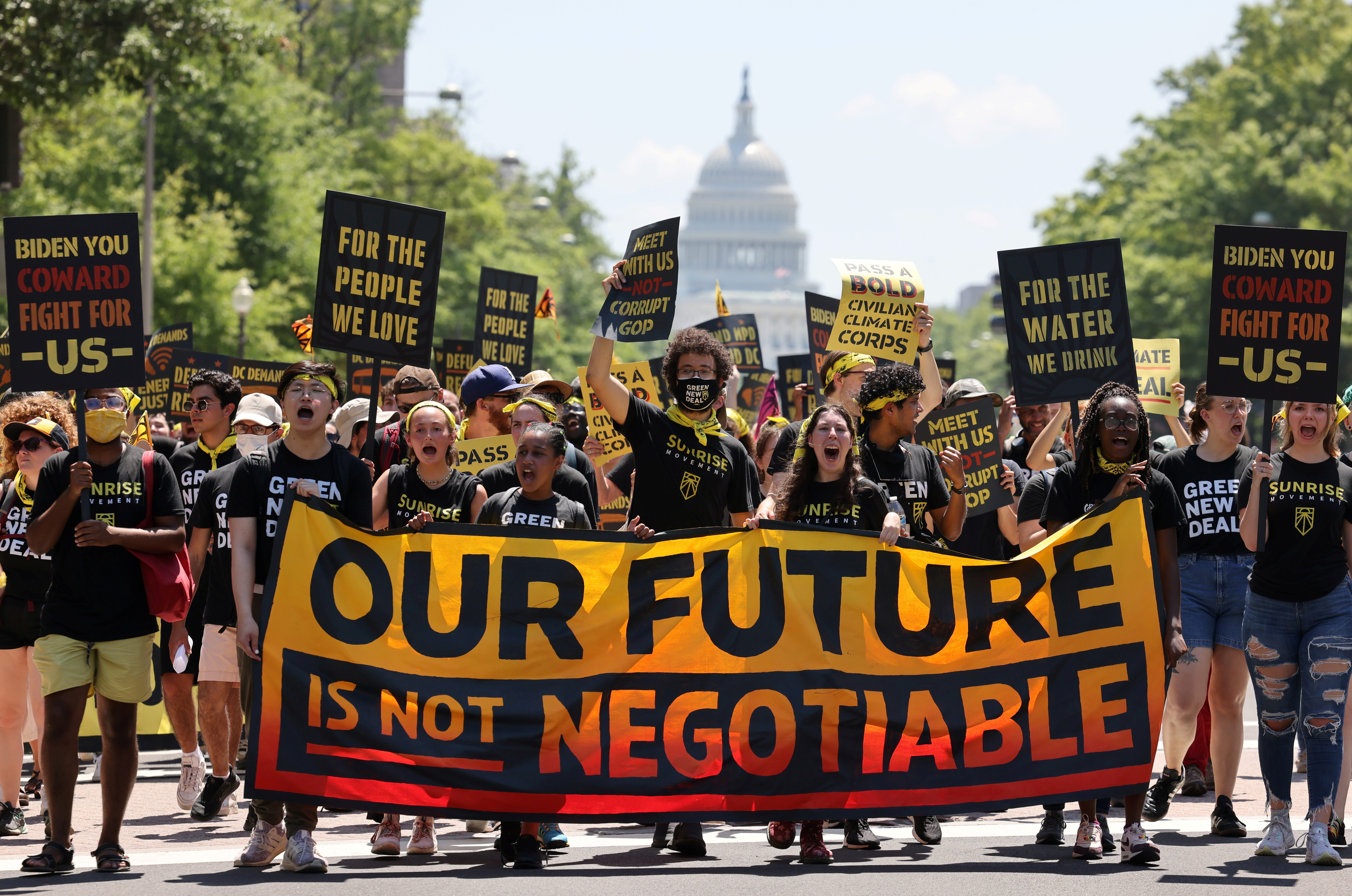 Demonstrators display signs and a banner during a "No Climate, No Deal" march on the White House, in Washington, D.C., on June 28, 2021. 