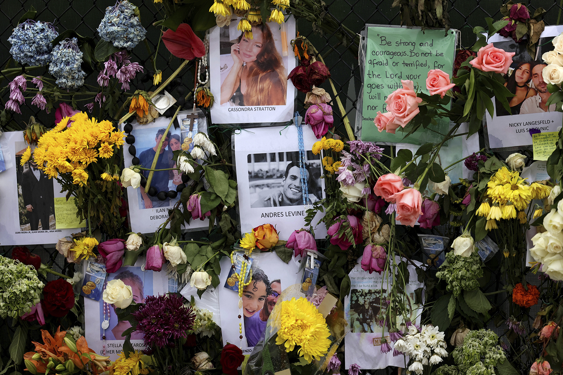 Photographs of victims hang on a memorial wall along a fence near the site at the Champlain Towers South Condo in Surfside, Fla., Wednesday, June 30, 2021. The apartment building partially collapsed on Thursday, June 24.
