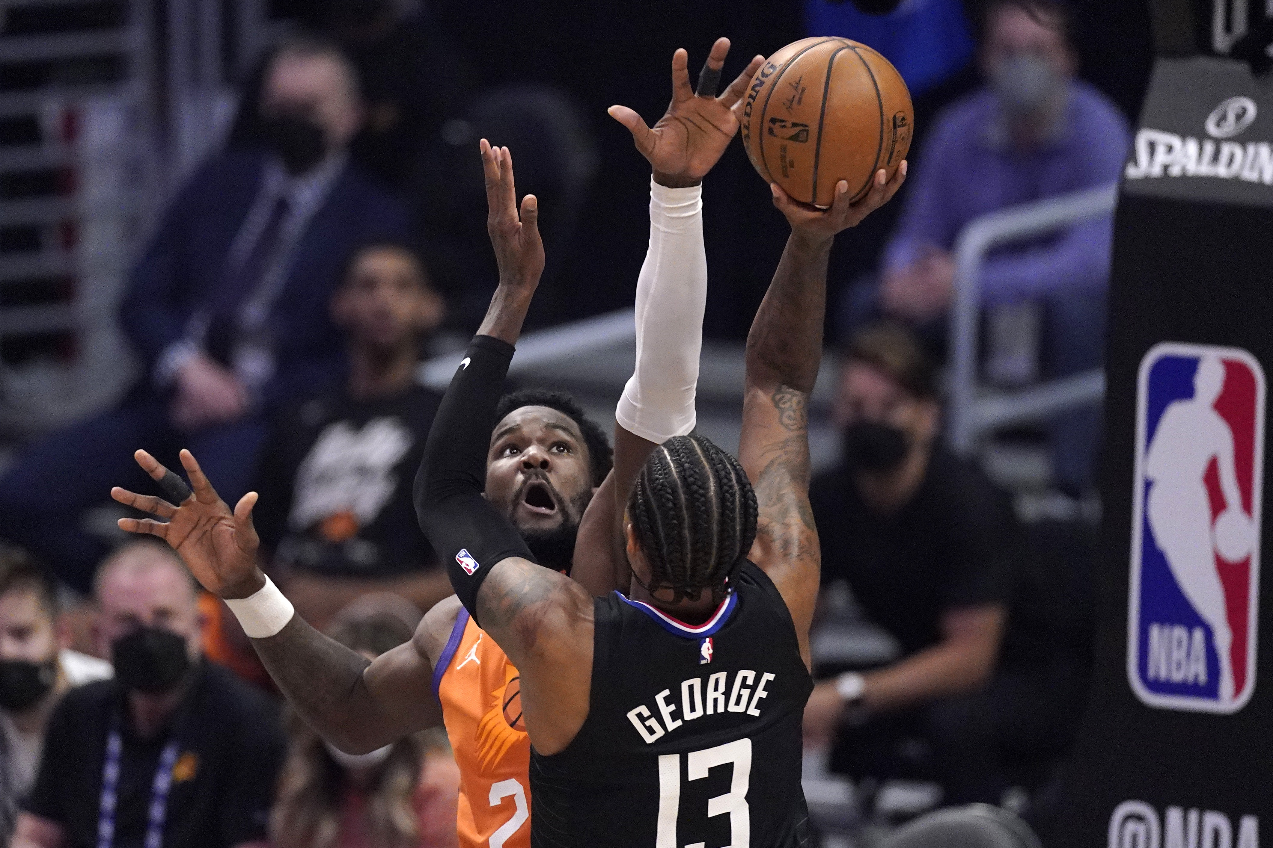 Los Angeles Clippers guard Paul George, right, shoots as Phoenix Suns center Deandre Ayton defends during the first half in Game 6 of the NBA basketball Western Conference Finals Wednesday, June 30, 2021, in Los Angeles.
