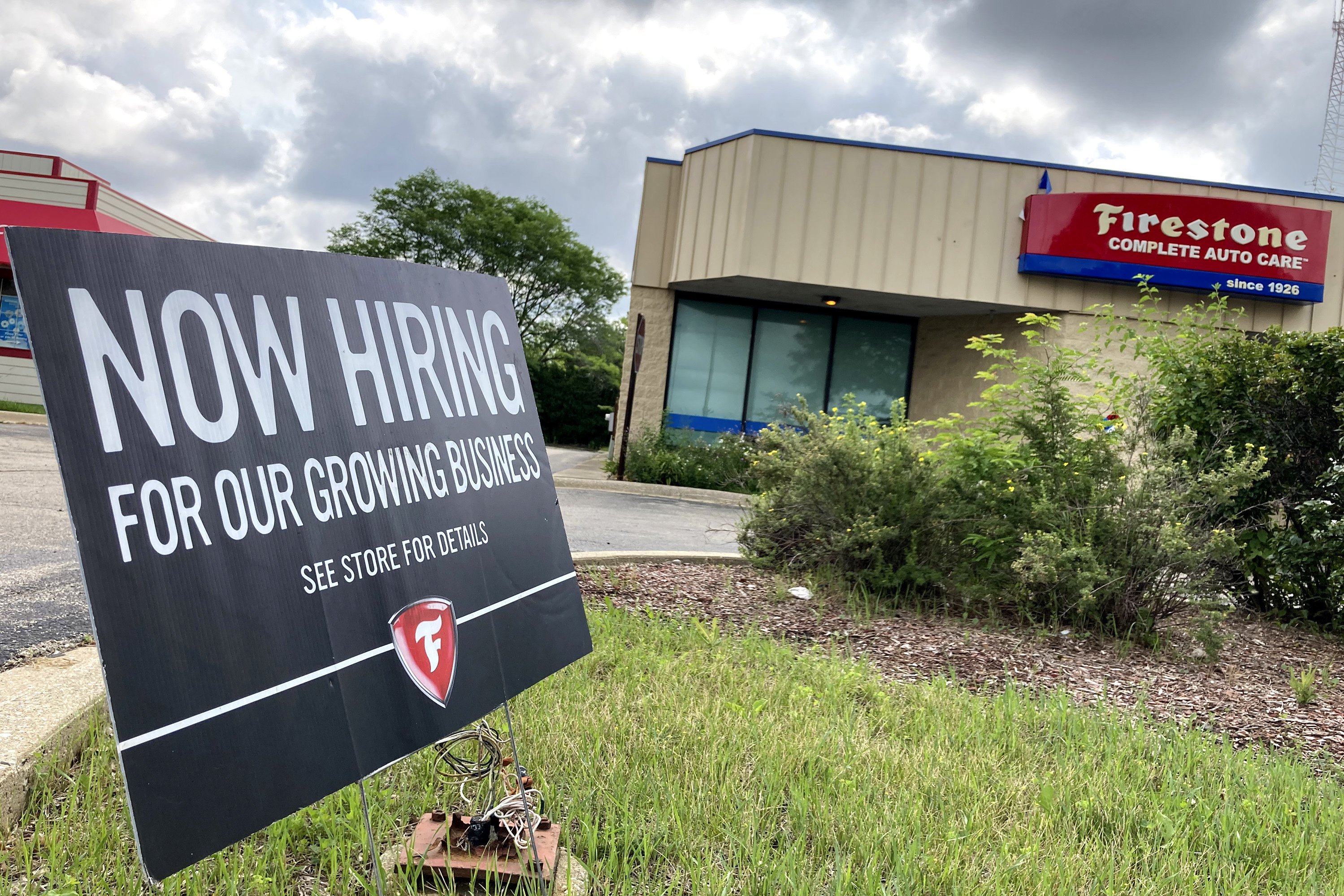A hiring sign is displayed at Firestone Complete Auto Care store in Arlington Heights, Ill., Wednesday, June 30, 2021. Illinois Gov. J.B. Pritzker said the state may join the list of others that may consider offering incentives for people to return to work.