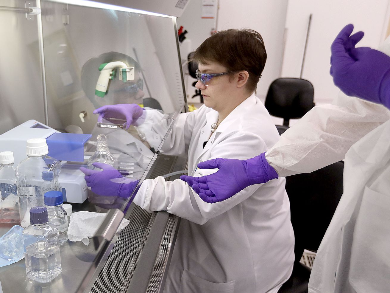 Lawrie Allred, HTS engineer, hands a cell plate to a
co-worker while seeding cells at Recursion Pharmaceuticals at The
Gateway in Salt Lake City on Oct. 30, 2018.