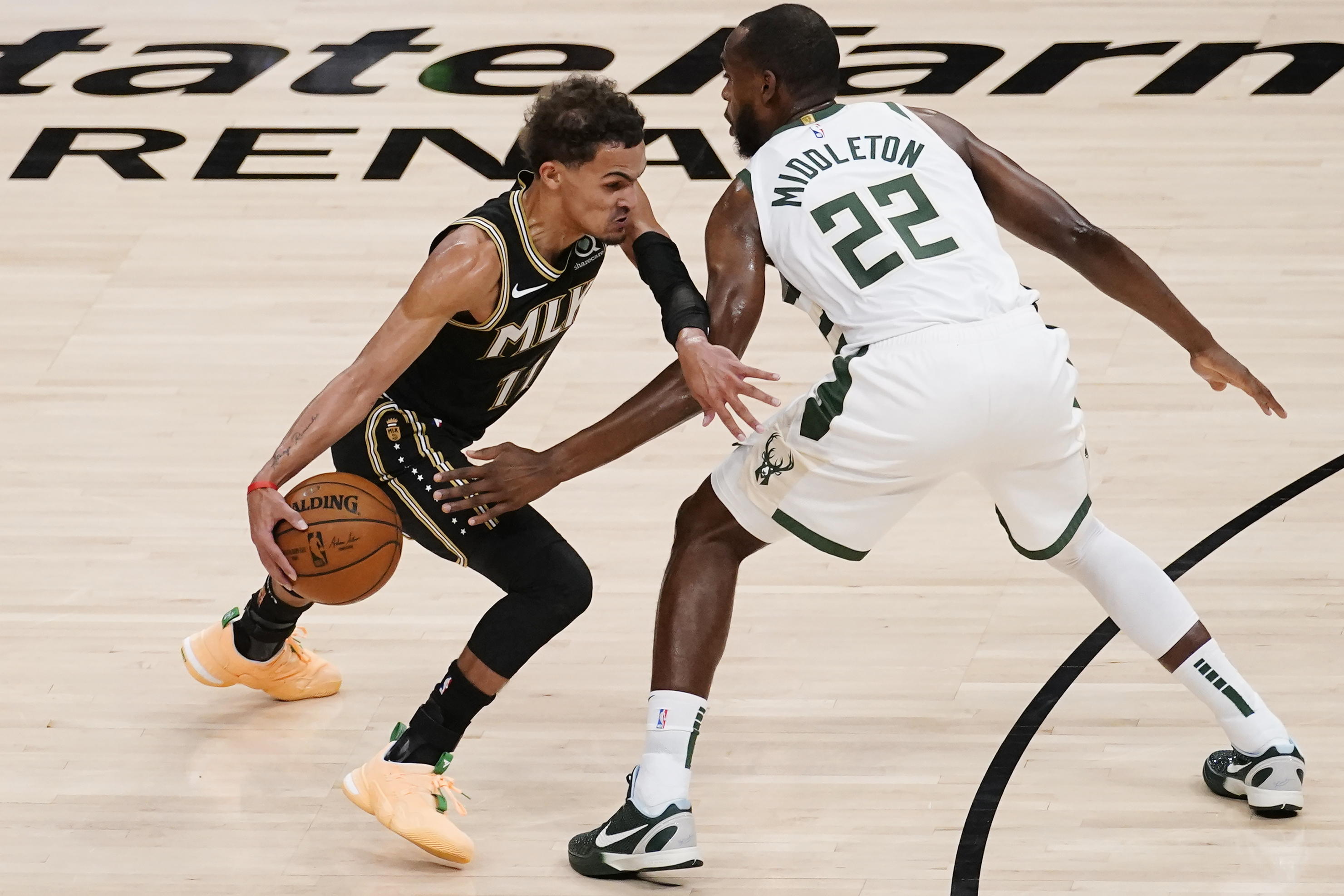 Atlanta Hawks guard Trae Young (11) drives past Milwaukee Bucks forward Khris Middleton (22) during the first half of Game 6 in the NBA basketball playoffs Eastern Conference finals Saturday, July 3, 2021, in Atlanta.