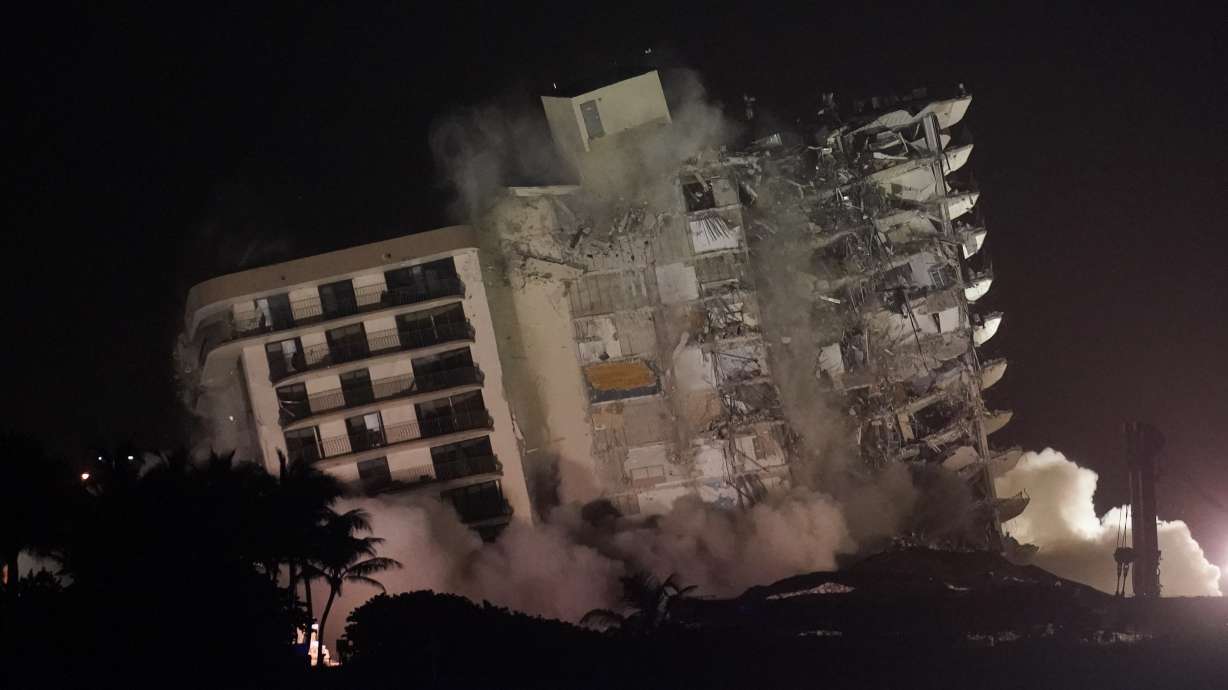 The damaged remaining structure at the Champlain Towers South condo building collapses in a controlled demolition, Sunday, July 4, 2021, in Surfside, Fla. The decision to demolish the Surfside building came after concerns mounted that the damaged structure was at risk of falling, endangering the crews below and preventing them from operating in some areas.