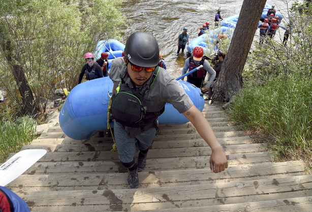 Kevin Perez, a rafting guide for Rocky Mountain Adventures, pulls an inflatable boat out of the water after taking a group down the Cache la Poudre River near Fort Collins, Colo., Wednesday, June 23, 2021. The river in northern Colorado is flowing well compared to waterways in the western part of the state, much of which is experiencing extreme drought.