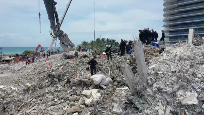 Search-and-rescue personnel work on the debris of the collapsed Champlain Towers South condominium in Surfside, Florida, U.S., July 5, 2021, in this still image obtained from video.