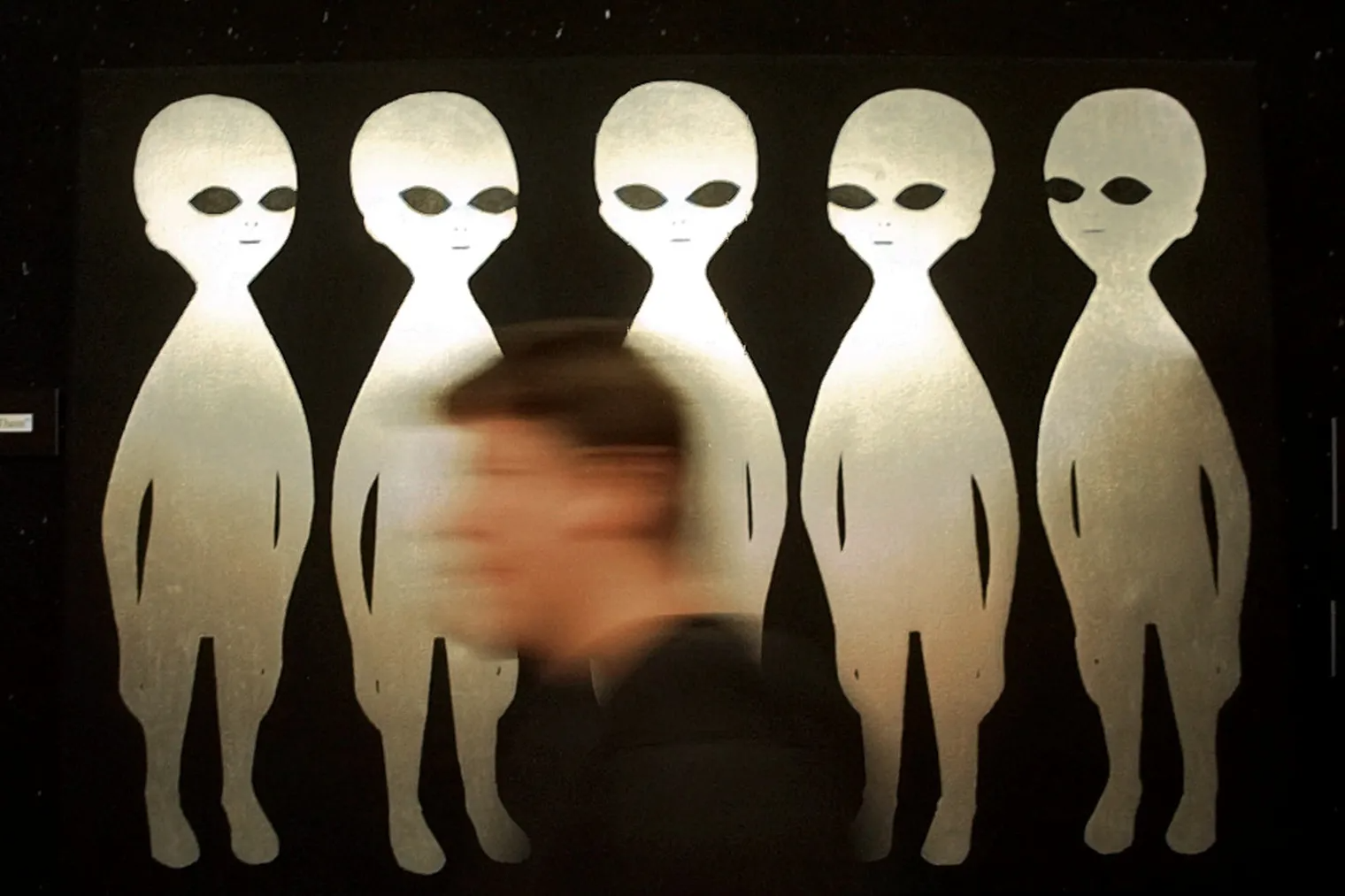 A patron passes a painting inside the International UFO Museum and Research Center in Roswell, N.M. in June 1997.