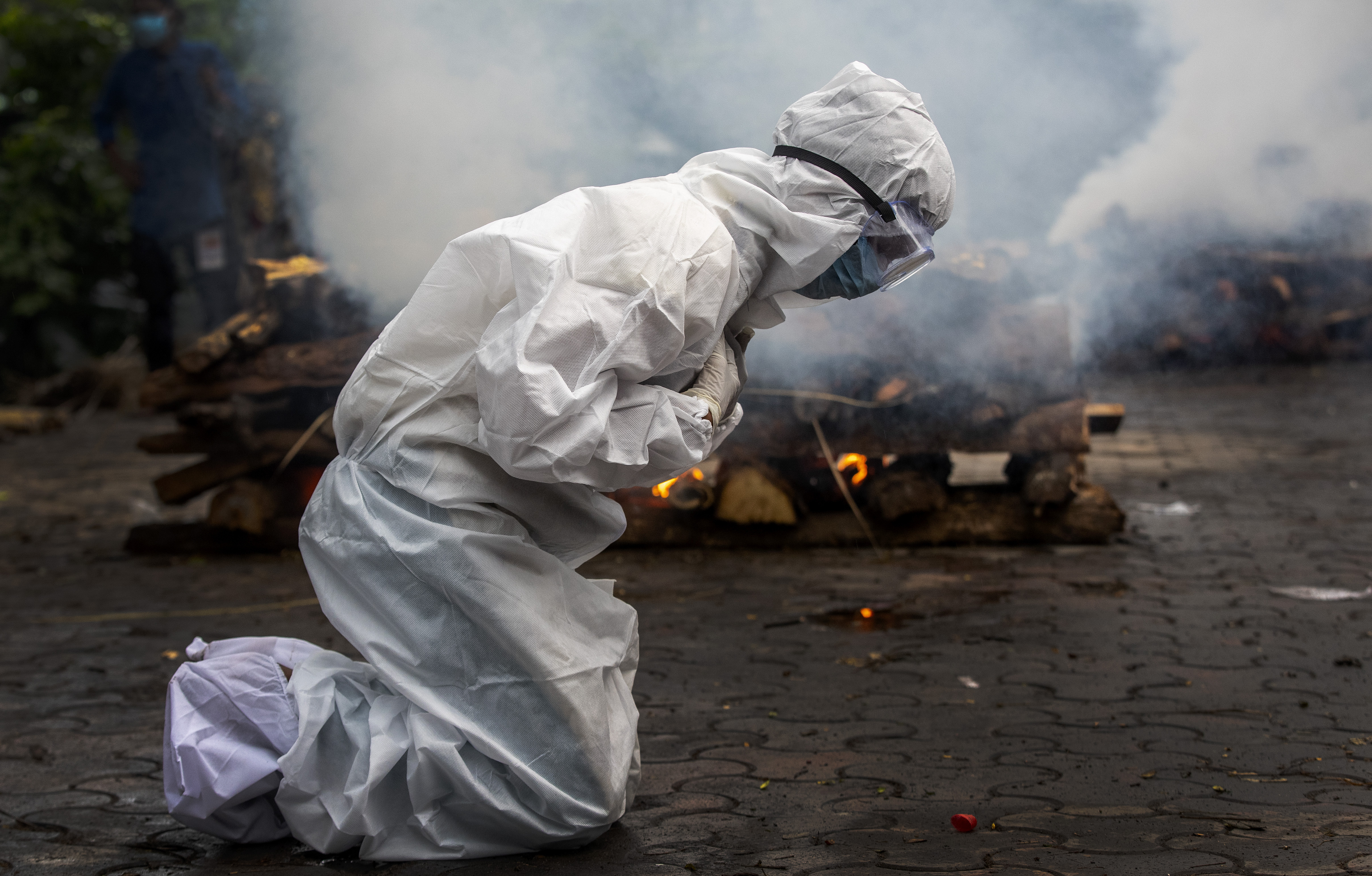 A woman breaks down on July 2, 2021, as she prays before the cremation of a relative who died of COVID-19 in Gauhati, India.