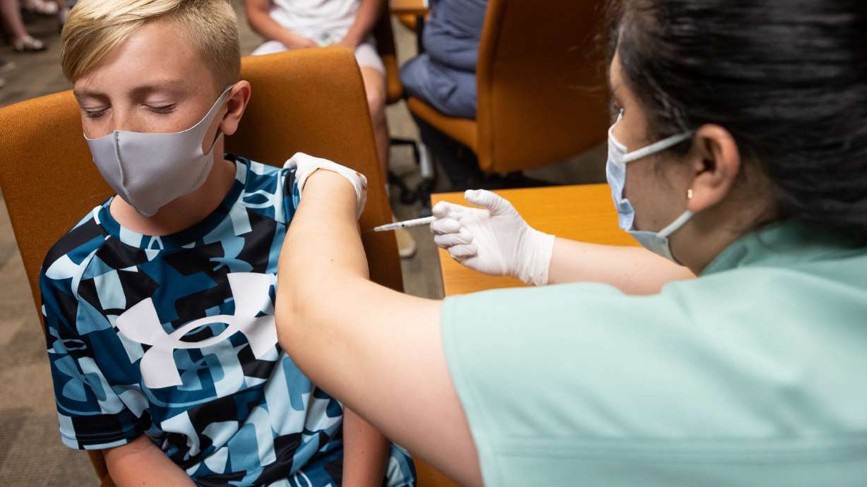 Jack Allen, 12, closes his eyes as he gets a shot of the Pfizer-BioNTech COVID-19 vaccine from nurse Estefania Cruz at the Central Davis Senior Activity Center in Kaysville on Tuesday, July 6, 2021.
