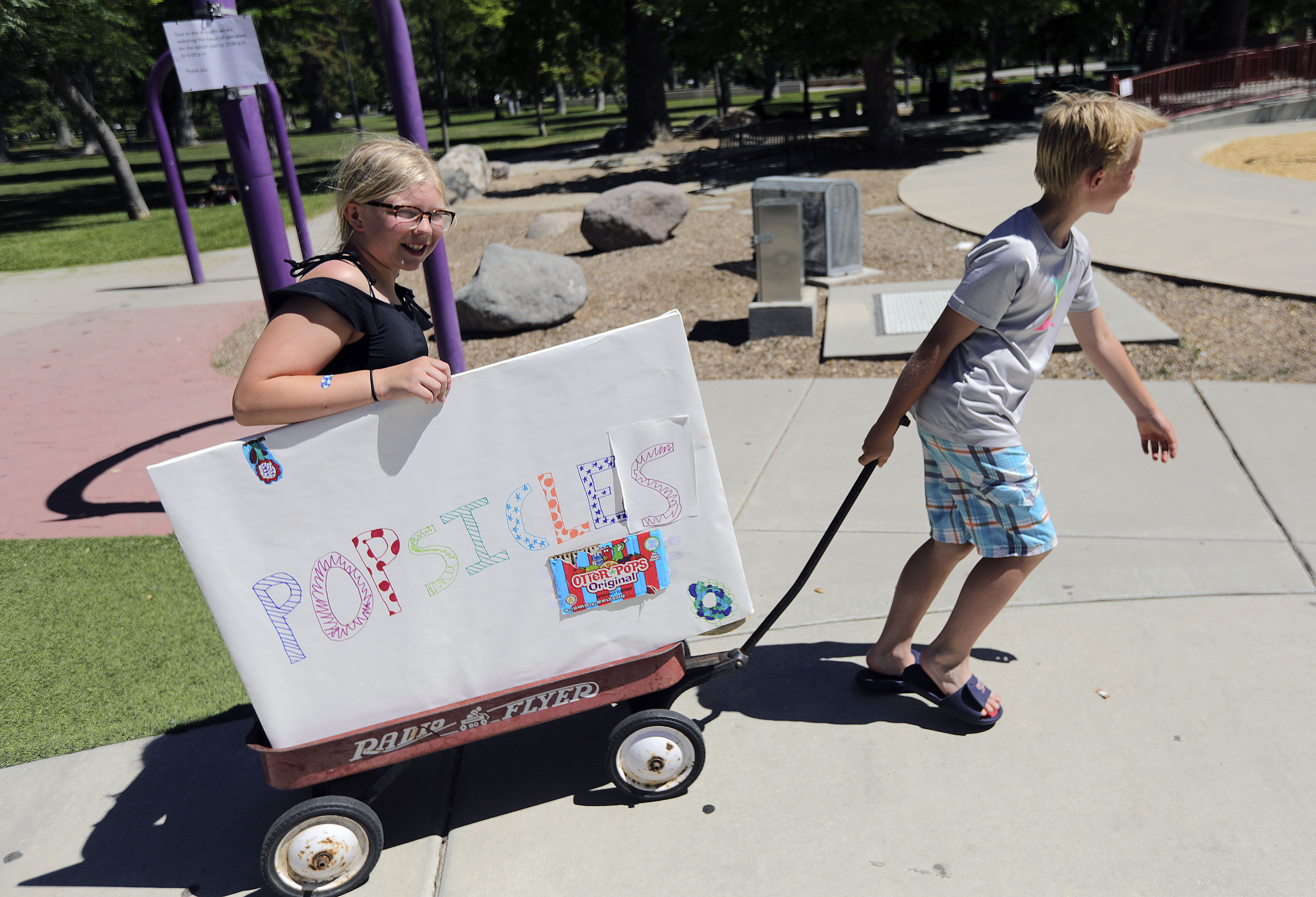 Charlotte Evans and Bart Evans sell popsicles during a heat wave in Liberty Park in Salt Lake City on Monday, June 14, 2021. With record-breaking temperatures, Utah officials are letting residents know financial assistance is available for those who can't afford to keep their air conditioners running. 