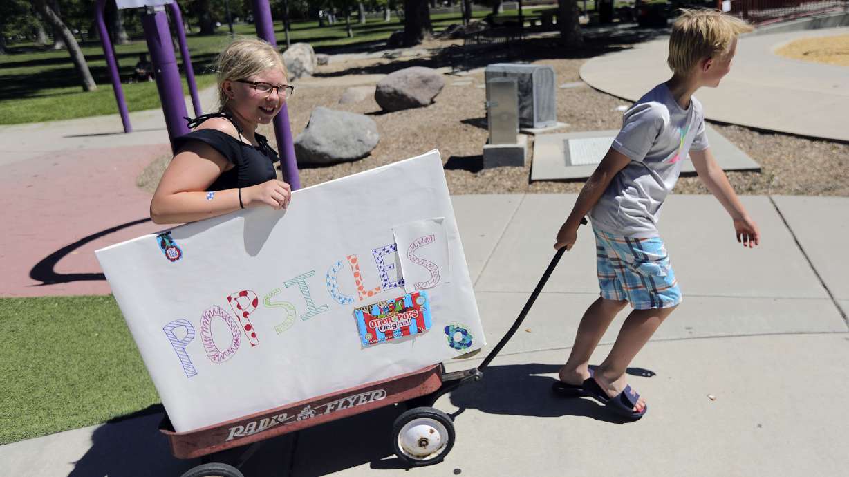 Charlotte Evans and Bart Evans sell popsicles during a heat wave in Liberty Park in Salt Lake City on Monday, June 14, 2021. With record-breaking temperatures, Utah officials are letting residents know financial assistance is available for those who can't afford to keep their air conditioners running.