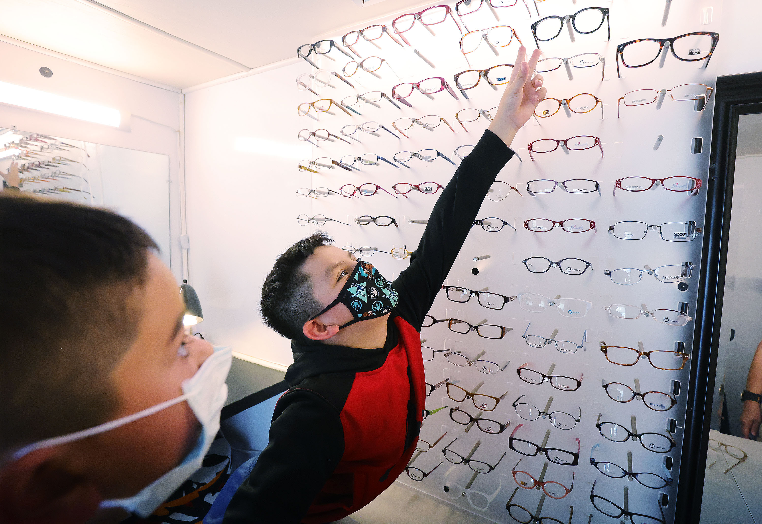 Santi Morales, 9, picks out eyeglass frames as Eye Care 4 Kids and its mobile clinic visit the Lied Boys and Girls Club in Glendale on Friday, July 9, 2021. Santi is the 400,000th child to be helped by the organization.