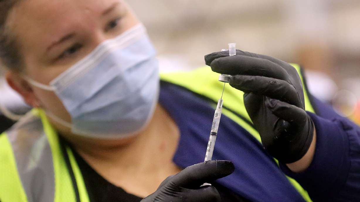 Aimee Koryta, a Davis County Health Department registered nurse, prepares a syringe of Pfizer-BioNTech COVID-19 vaccine at the Legacy Center Indoor Arena in Farmington on Tuesday, Jan. 12, 2021.