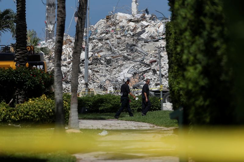 Search teams walk by the remains of Surfside's Champlain Towers South condominium in Miami, Florida, on July 8, 2021. The death toll from the partial collapse of the condominium rose by four to 94, with 22 people still unaccounted for.