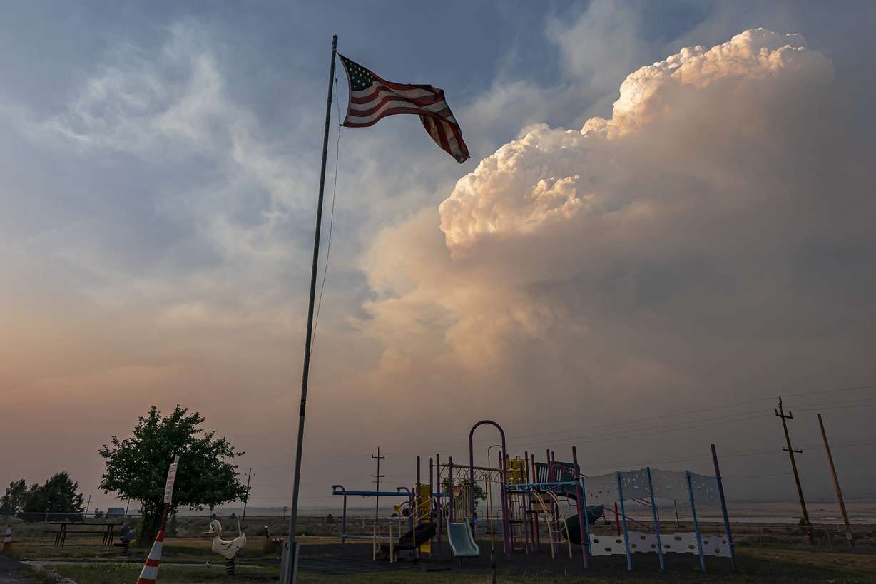 Plumes of smoke from the Bootleg Fire rise over a playground, Monday, July 12, 2021, near Bly, Ore.