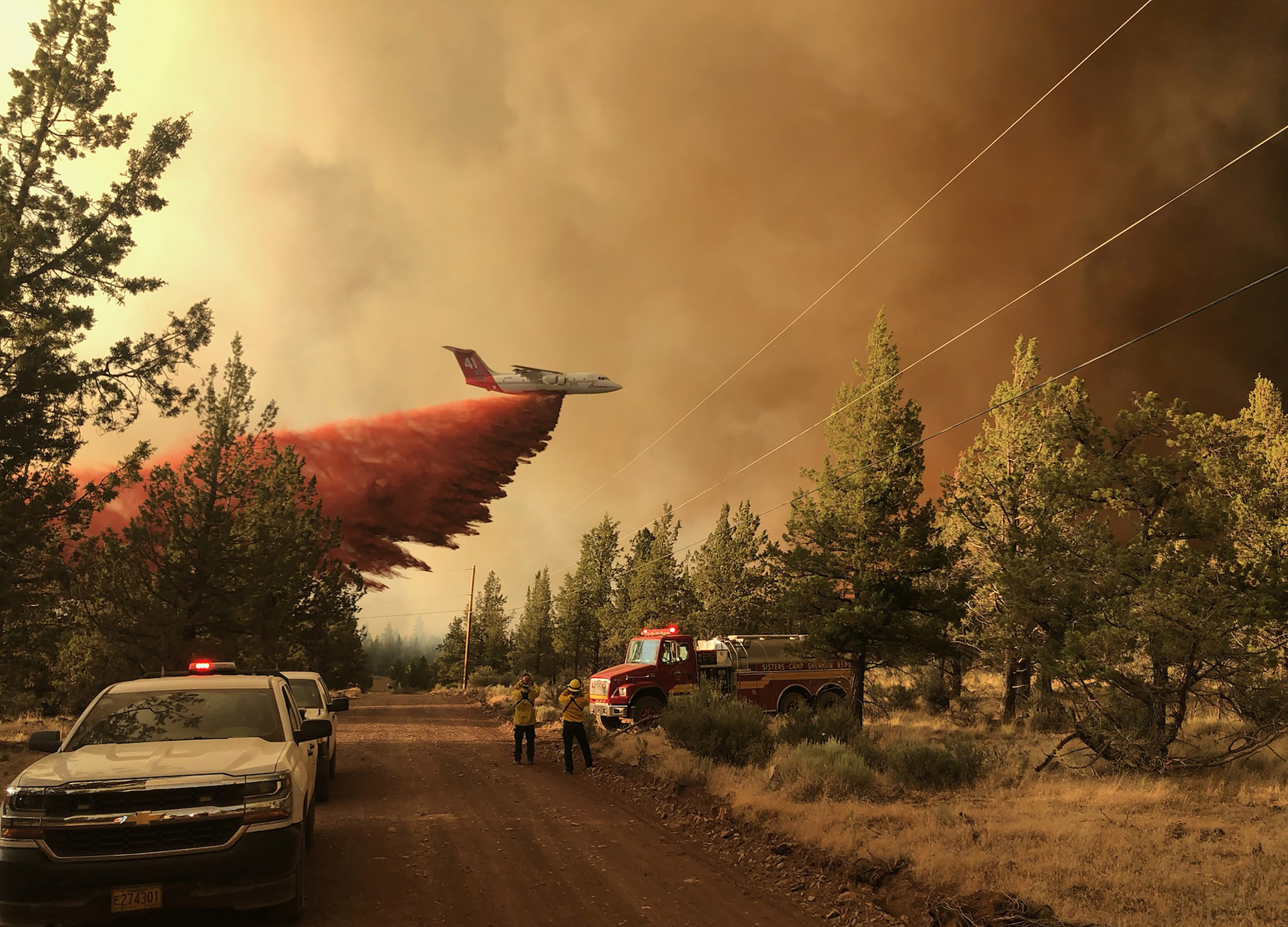 This photo provided by the Oregon Department of Forestry shows a firefighting tanker making a retardant drop over the Grandview Fire near Sisters, Ore., Sunday, July 11, 2021. The wildfire doubled in size Monday, forcing evacuations in the area while the state's biggest fire continued to burn out of control, with containment not expected until November.