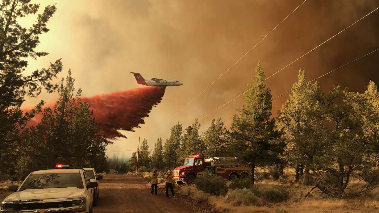 This photo provided by the Oregon Department of Forestry shows a firefighting tanker making a retardant drop over the Grandview Fire near Sisters, Ore., Sunday, July 11, 2021. The wildfire doubled in size Monday, forcing evacuations in the area while the state's biggest fire continued to burn out of control, with containment not expected until November.