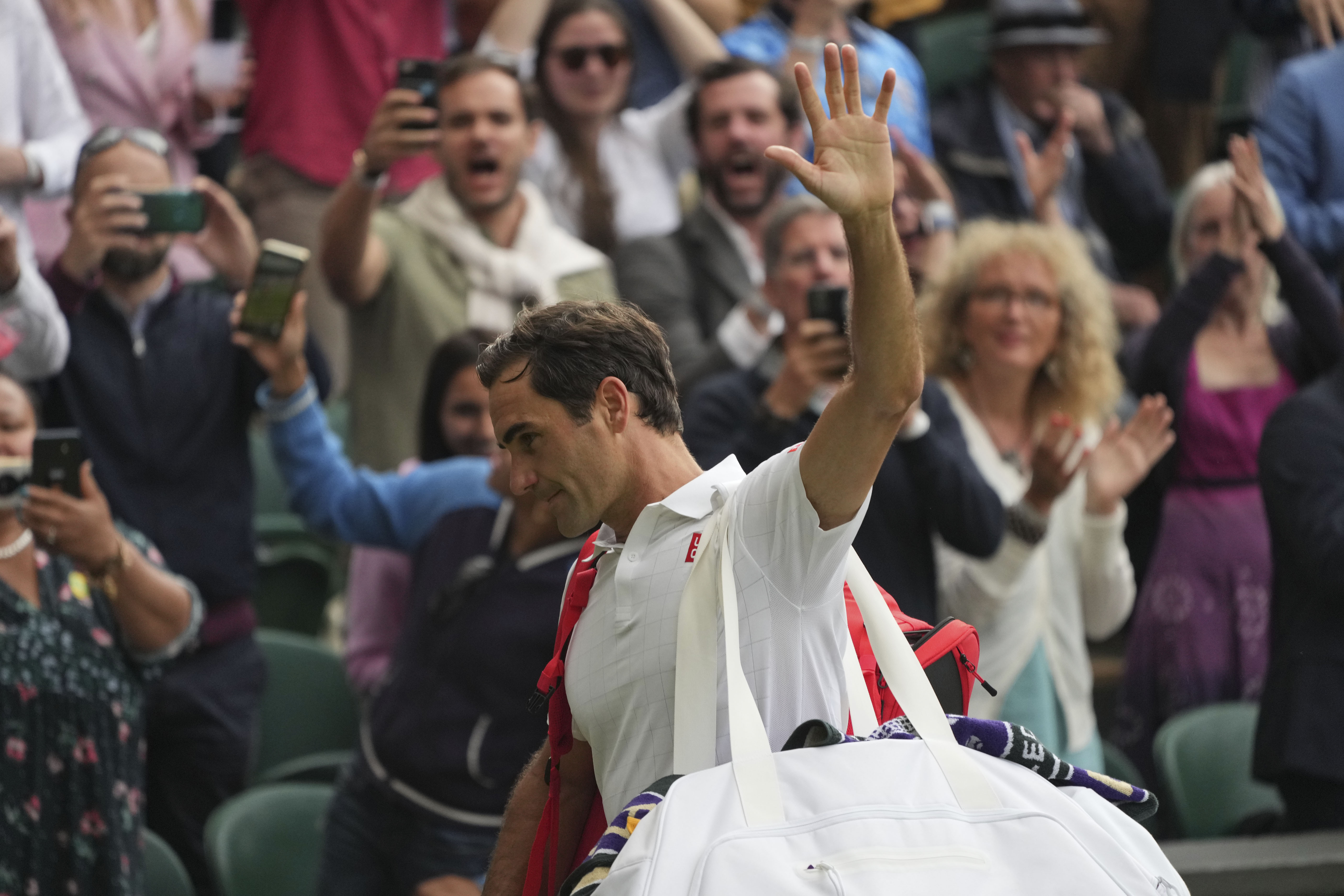 Switzerland's Roger Federer leaves the court after being defeated by Poland's Hubert Hurkacz during the men's singles quarterfinals match on day nine of the Wimbledon Tennis Championships in London, Wednesday, July 7, 2021.