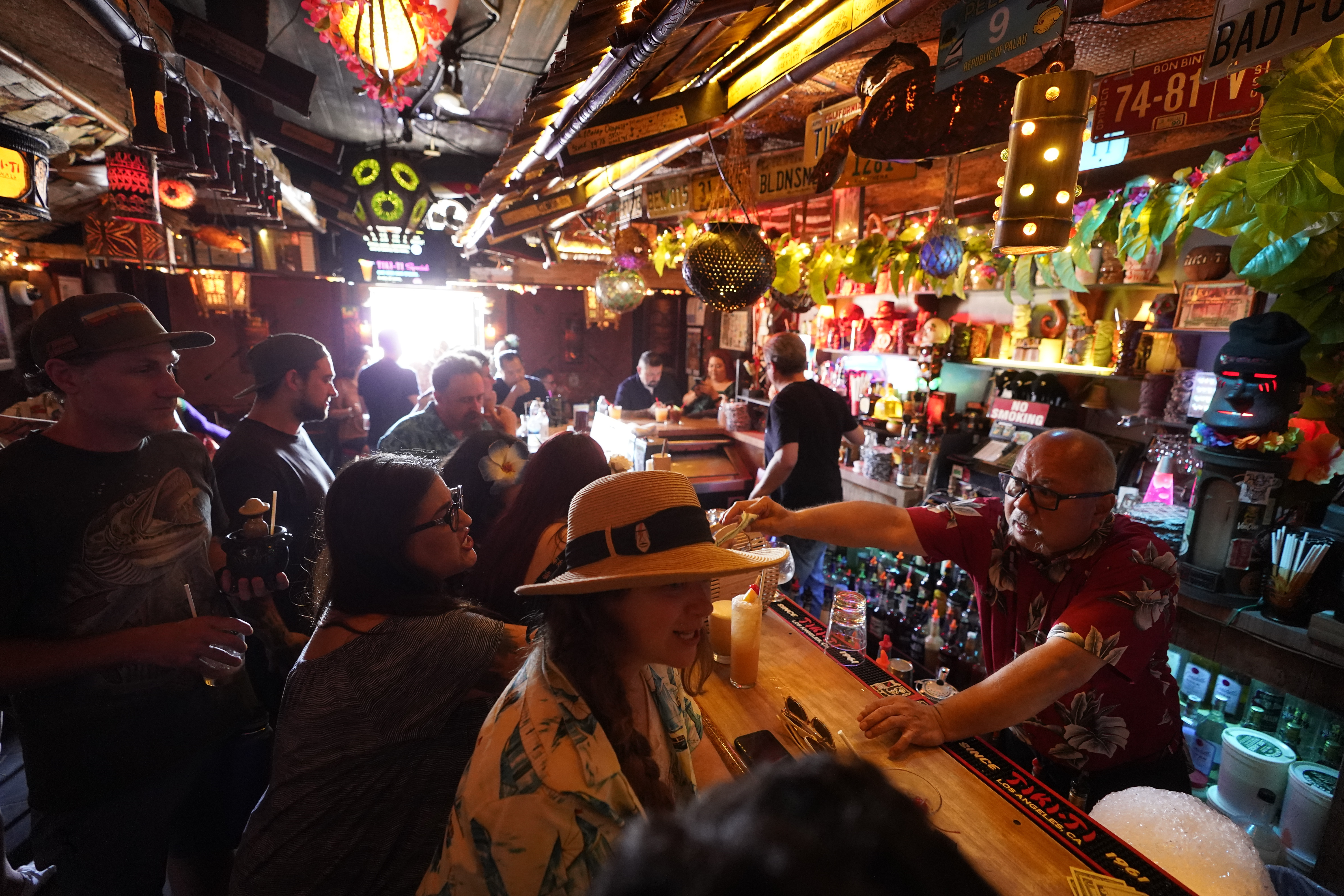 Patrons enjoy cold tropical cocktails in the tiny interior of the Tiki-Ti bar as it reopens on Sunset Boulevard in Los Angeles. COVID-19 cases have doubled over the past three weeks, driven by the fast-spreading delta variant, lagging vaccination rates in some states and Fourth of July gatherings.