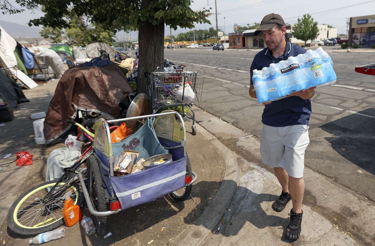 Ed Bluemel delivers a case of water to a homeless camp on 800 South during a heat wave in Salt Lake City on Monday, July 12, 2021. Bluemel and his brother, Cory Bluemel, raised over $700 to deliver ice, beverages and snacks to the homeless.
