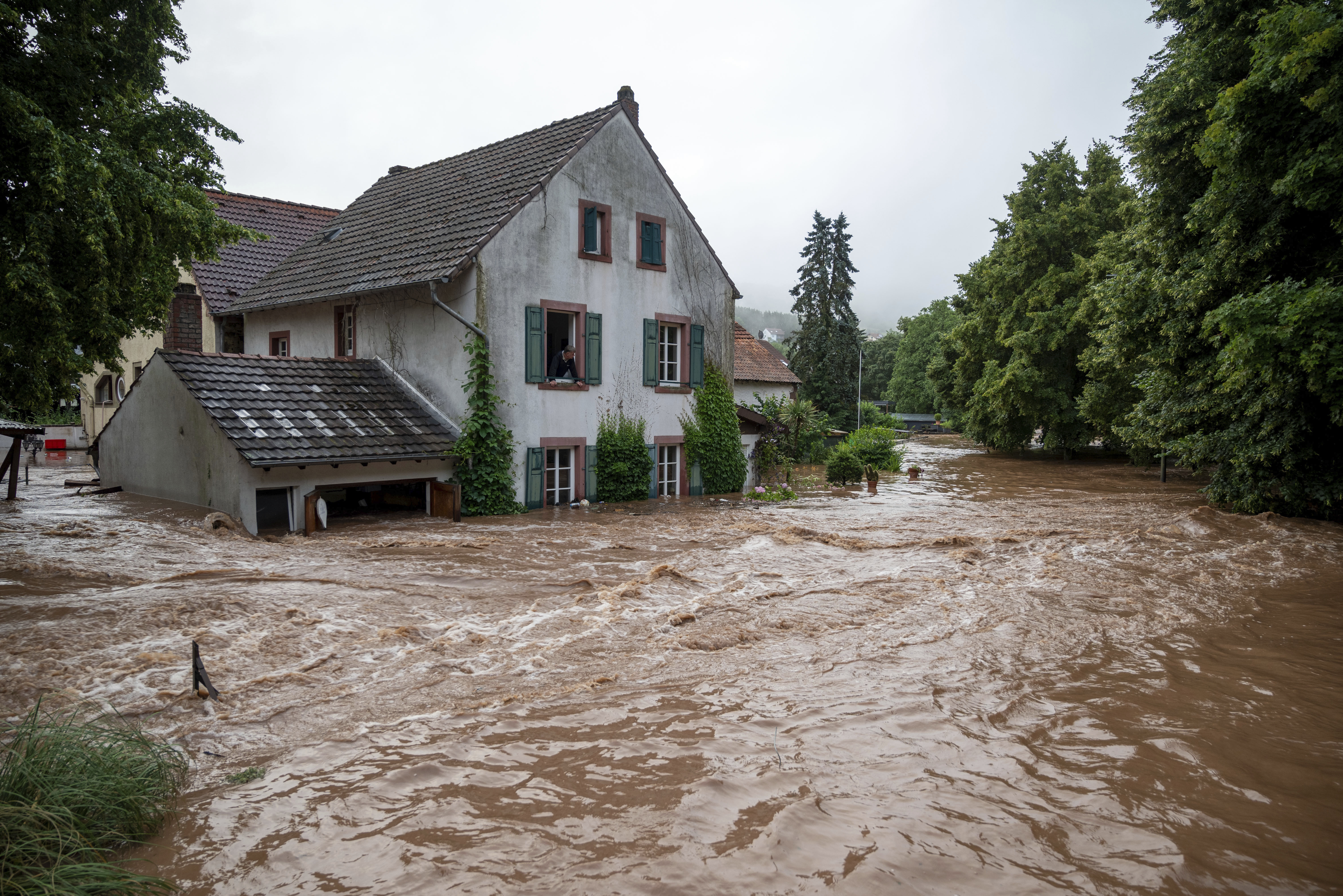 Houses are submerged on the overflowed river banks in Erdorf, Germany, as the village was flooded Thursday, July 15, 2021. Continuous rainfall has flooded numerous villages and cellars in Rhineland-Palatinate, southwestern Germany.